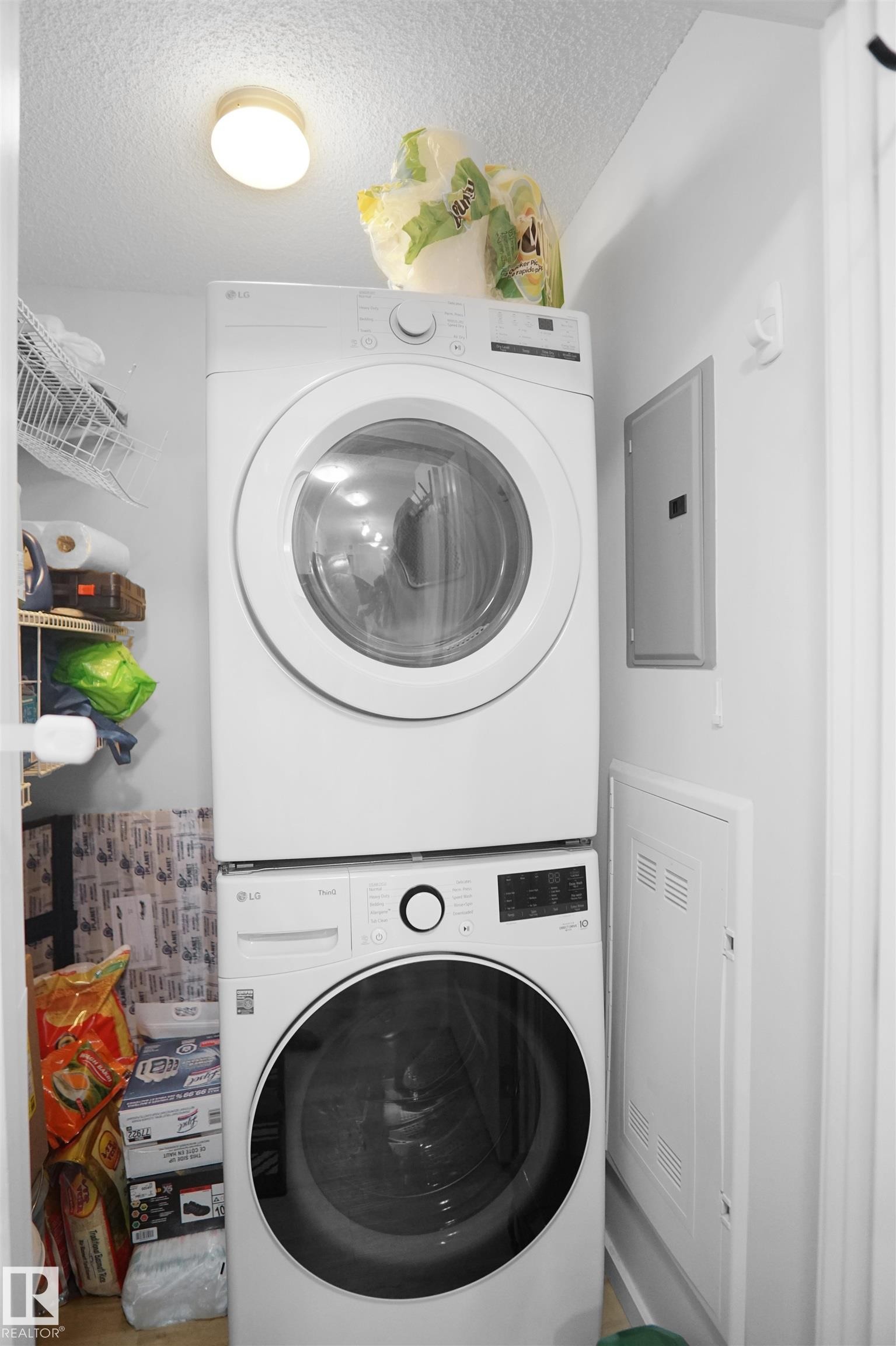 The property features a dedicated laundry area with a stacked washer and dryer, providing convenience - 103 3353 16A Avenue, Edmonton, AB - Indoor Photo Showing Laundry Room