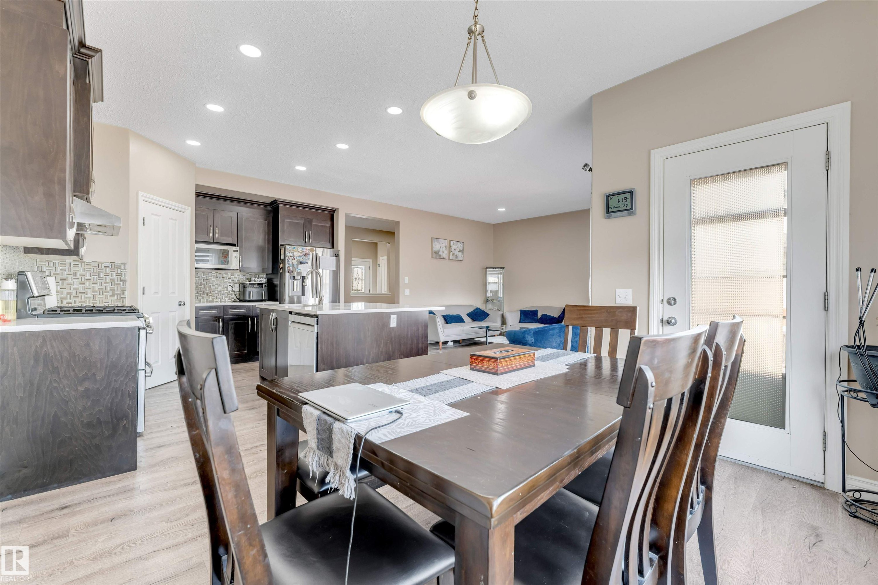 The property features an open-concept living space with a dining area, a kitchen with dark cabinetry, and a living room with light-colored walls - 121 64 Street, Edmonton, AB - Indoor Photo Showing Dining Room