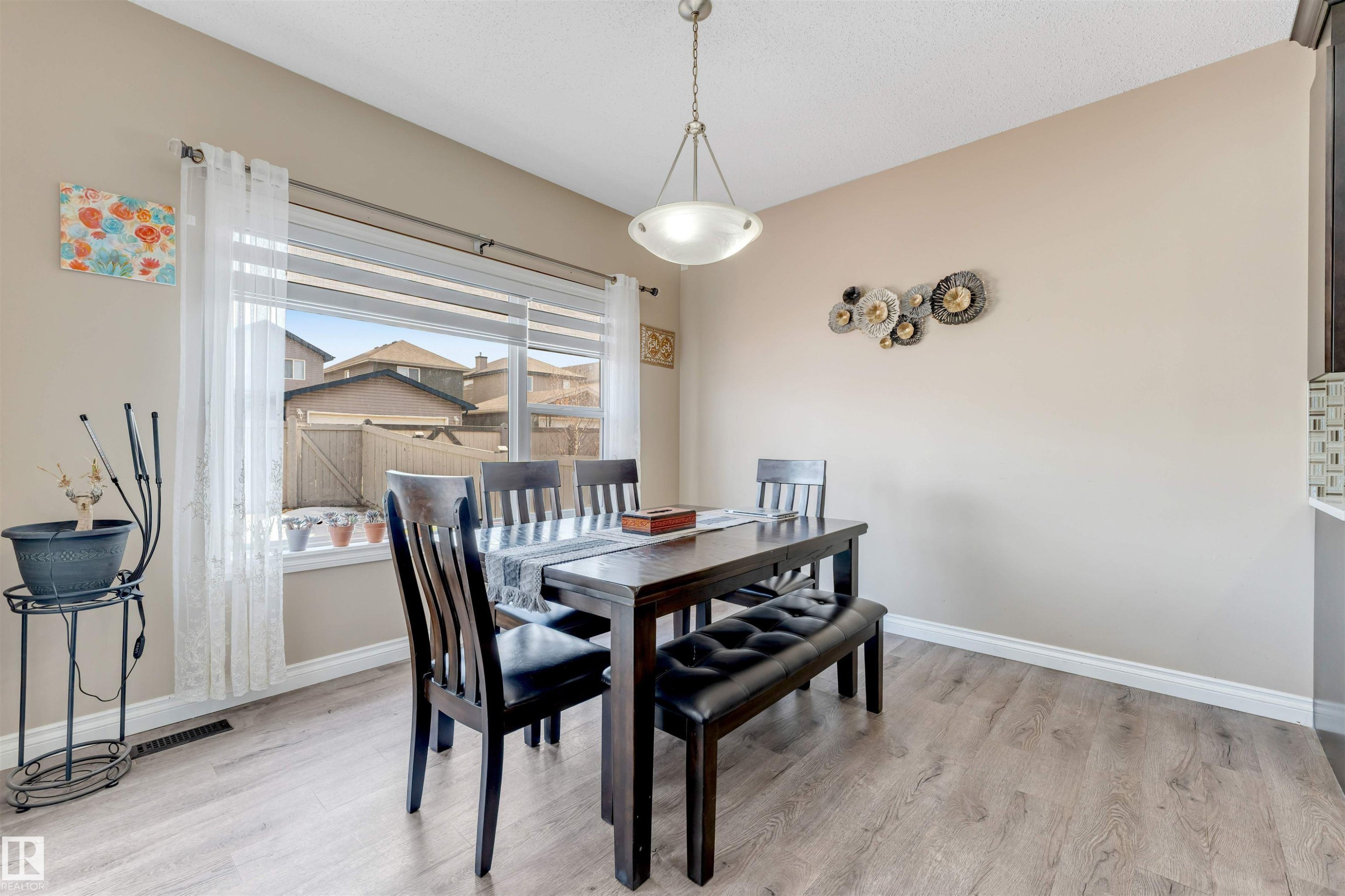 This dining area features light-colored walls and flooring, with a window providing natural light - 121 64 Street, Edmonton, AB - Indoor Photo Showing Dining Room