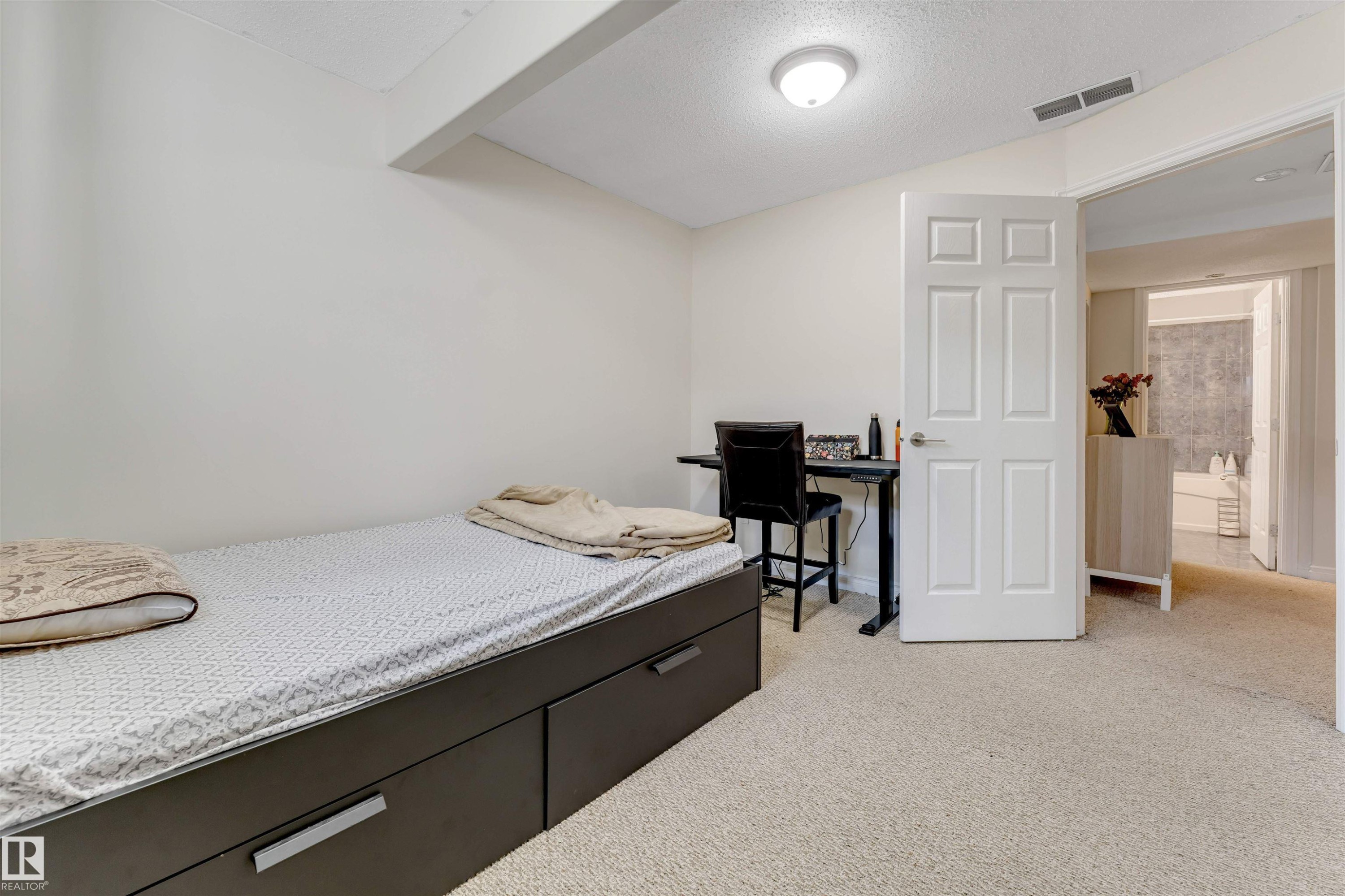 This room features light-colored walls and carpeting, a ceiling light fixture, and a white paneled door - 121 64 Street, Edmonton, AB - Indoor Photo Showing Bedroom
