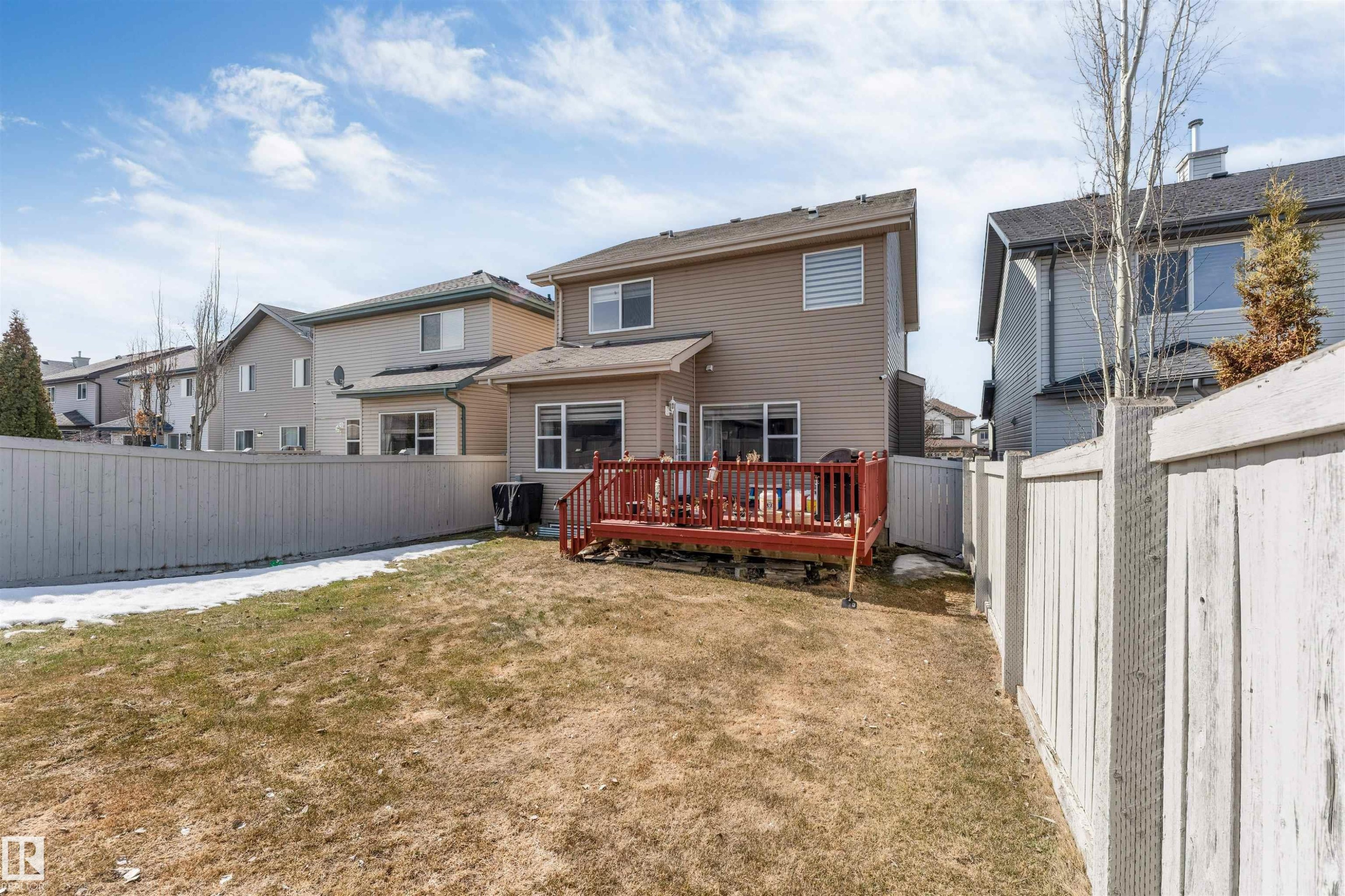 The property features a fenced yard with a deck and established trees - 121 64 Street, Edmonton, AB - Outdoor