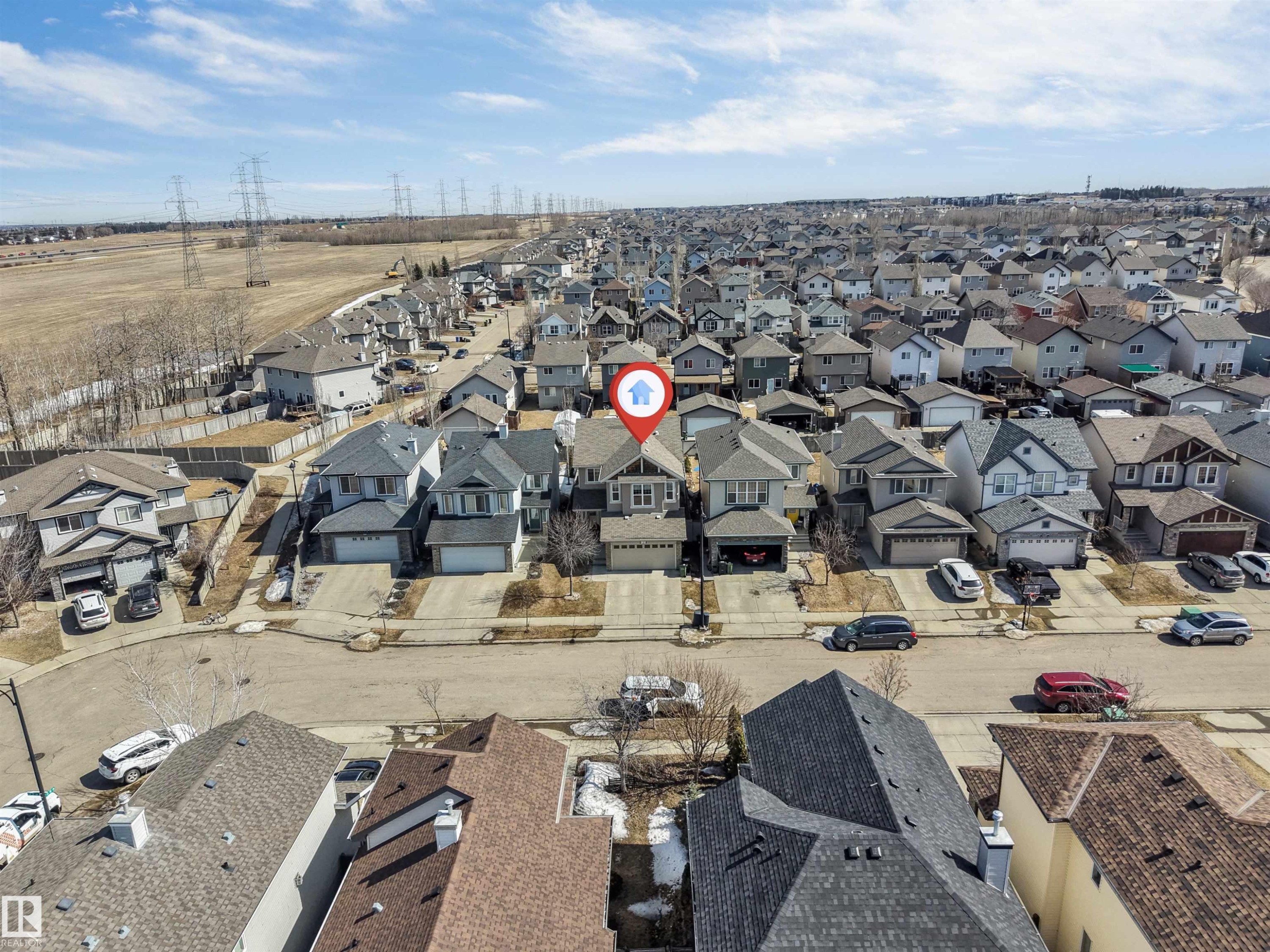 Aerial view of the property with a two-car garage, located within a residential community featuring diverse housing styles - 121 64 Street, Edmonton, AB - Outdoor With View
