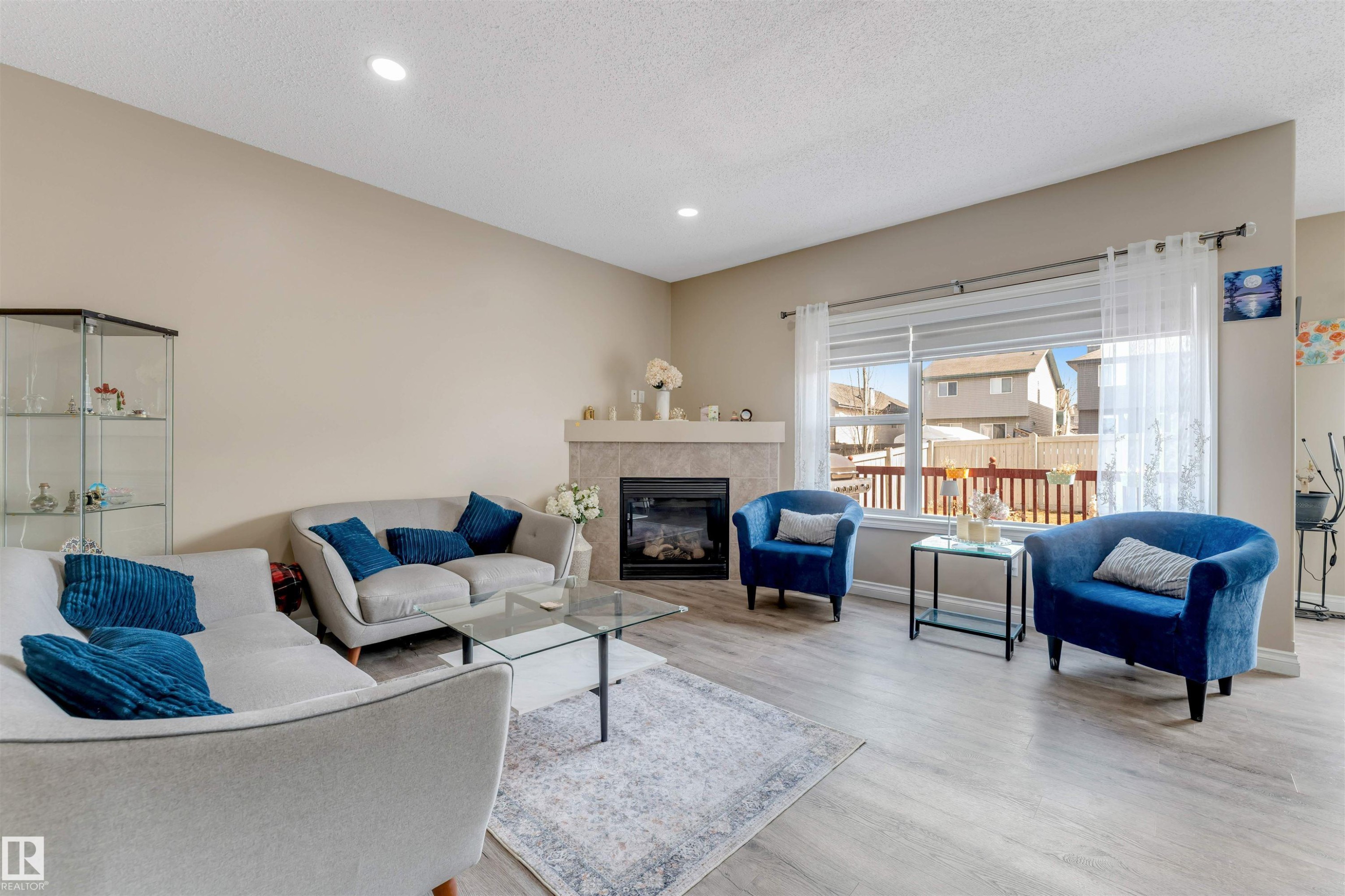 The living area features light-colored flooring and a fireplace with a light-toned mantel - 121 64 Street, Edmonton, AB - Indoor Photo Showing Living Room With Fireplace