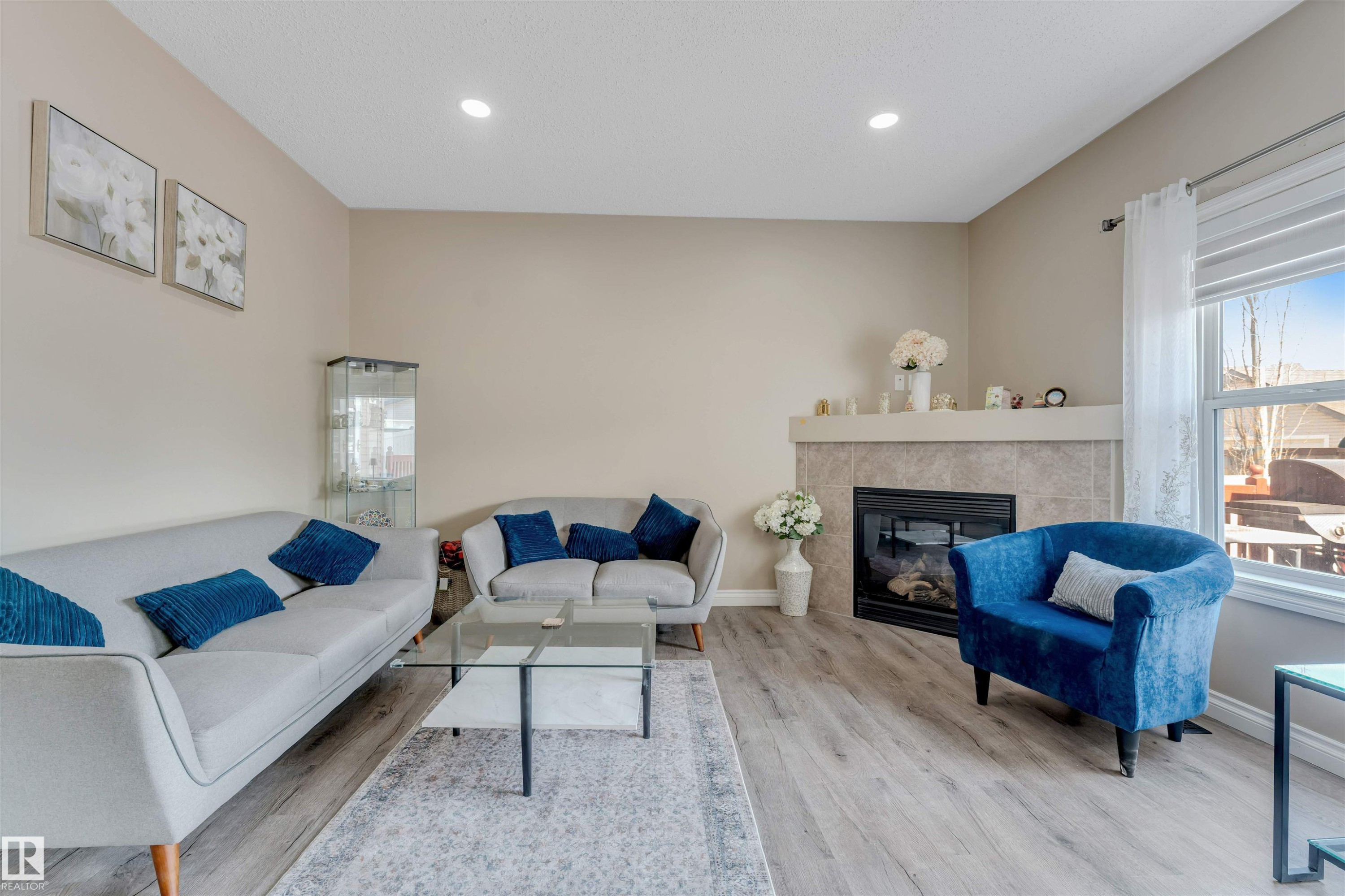 The living room features light-colored walls, recessed ceiling lights, and light wood-style flooring - 121 64 Street, Edmonton, AB - Indoor Photo Showing Living Room With Fireplace