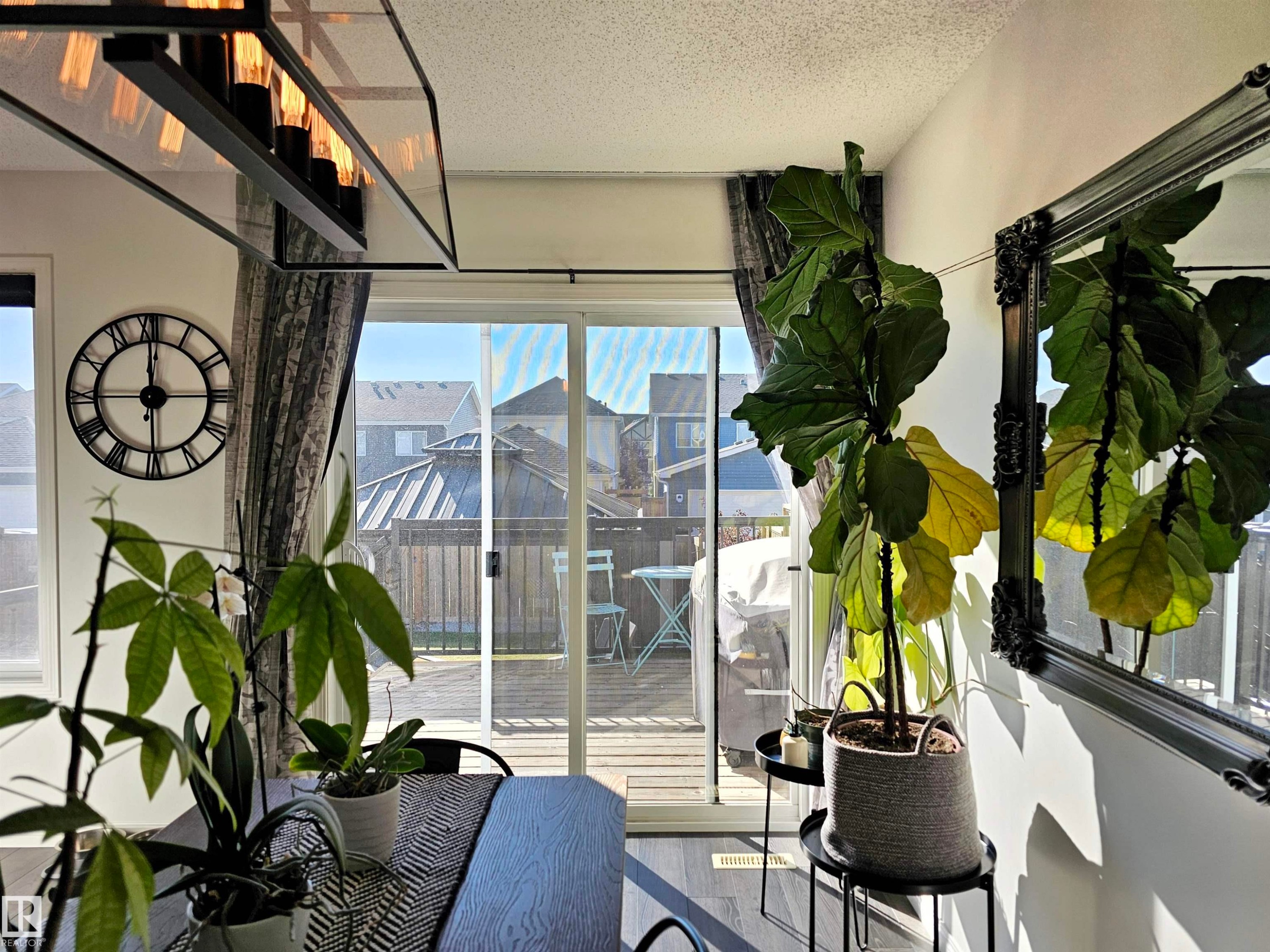 The dining area features a modern linear light fixture and large sliding glass doors providing access to an outdoor deck - 6888 Evans Wynd, Edmonton, AB - Indoor Photo Showing Other Room