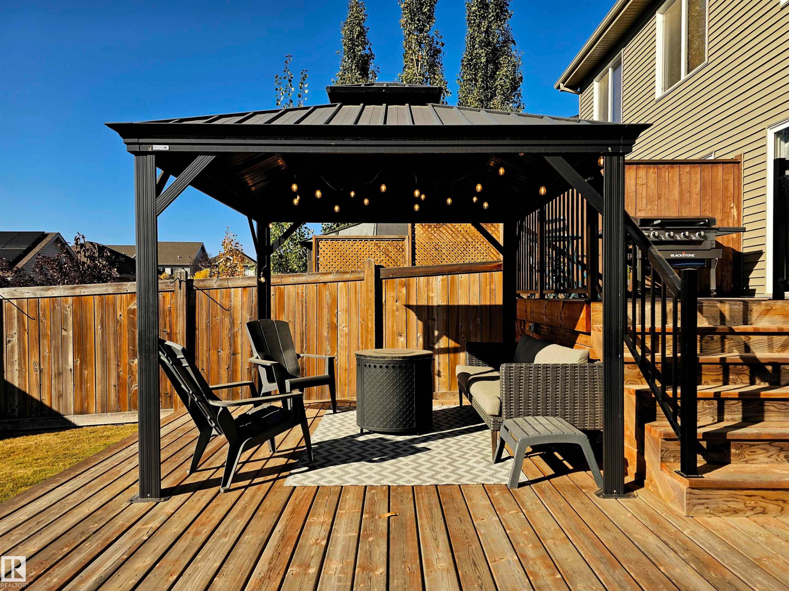 The property features a spacious wooden deck with a black gazebo, providing an inviting outdoor living area - 6888 Evans Wynd, Edmonton, AB - Outdoor With Deck Patio Veranda With Exterior