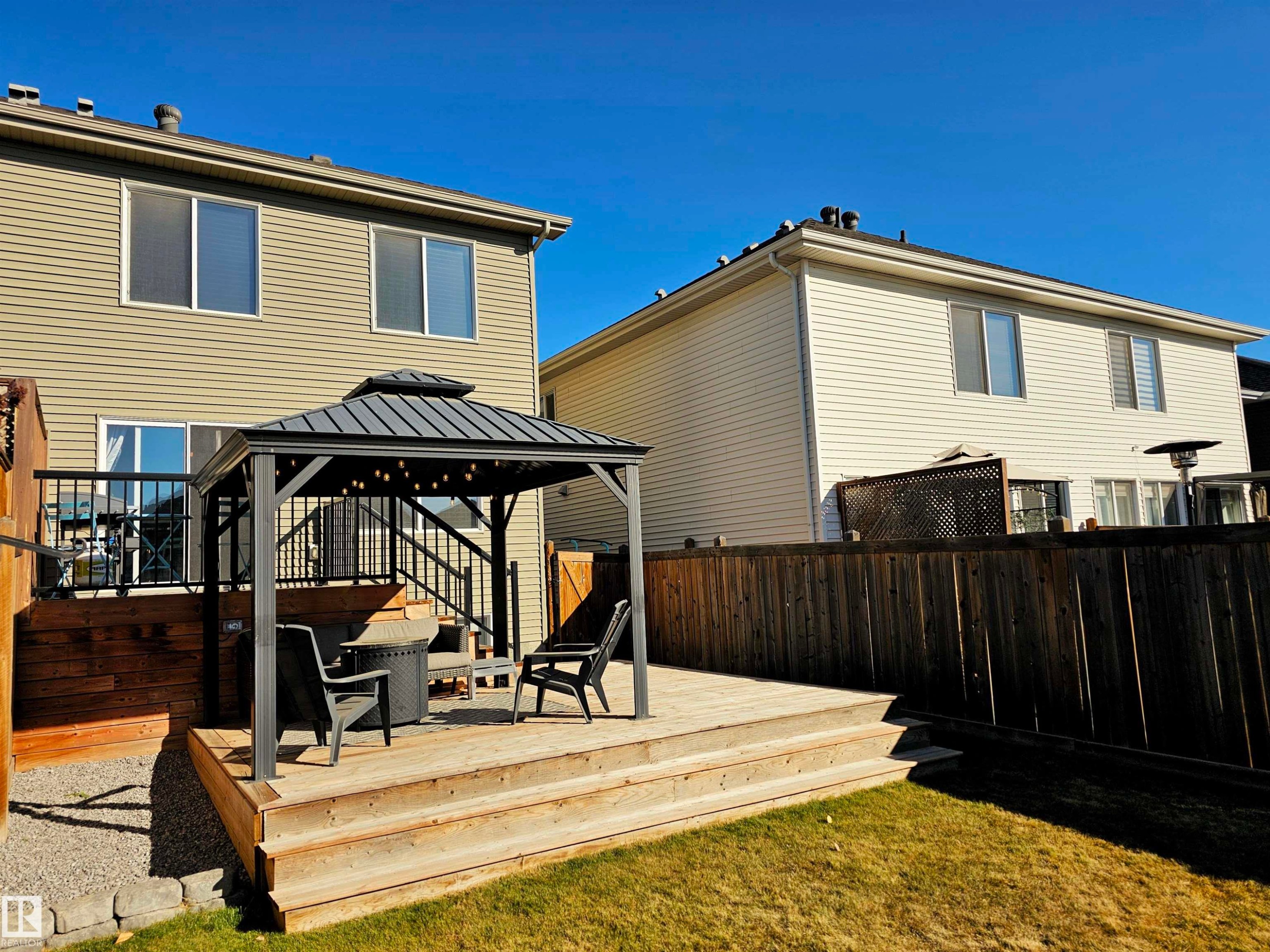 The property includes a spacious deck with a gazebo, featuring seating and ambient lighting - 6888 Evans Wynd, Edmonton, AB - Outdoor With Deck Patio Veranda With Exterior