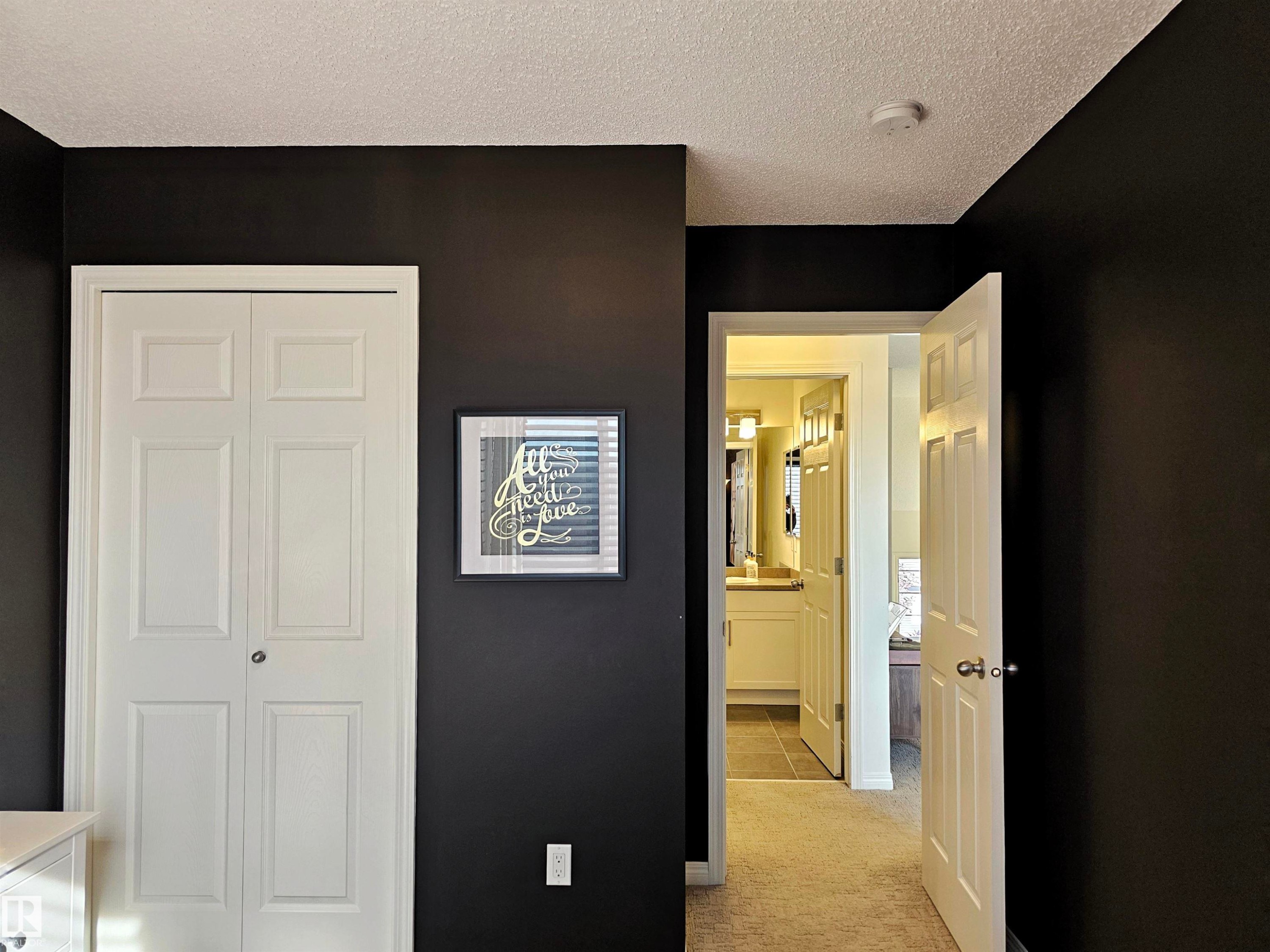 This space features dark walls and light-colored trim - 6888 Evans Wynd, Edmonton, AB - Indoor Photo Showing Other Room