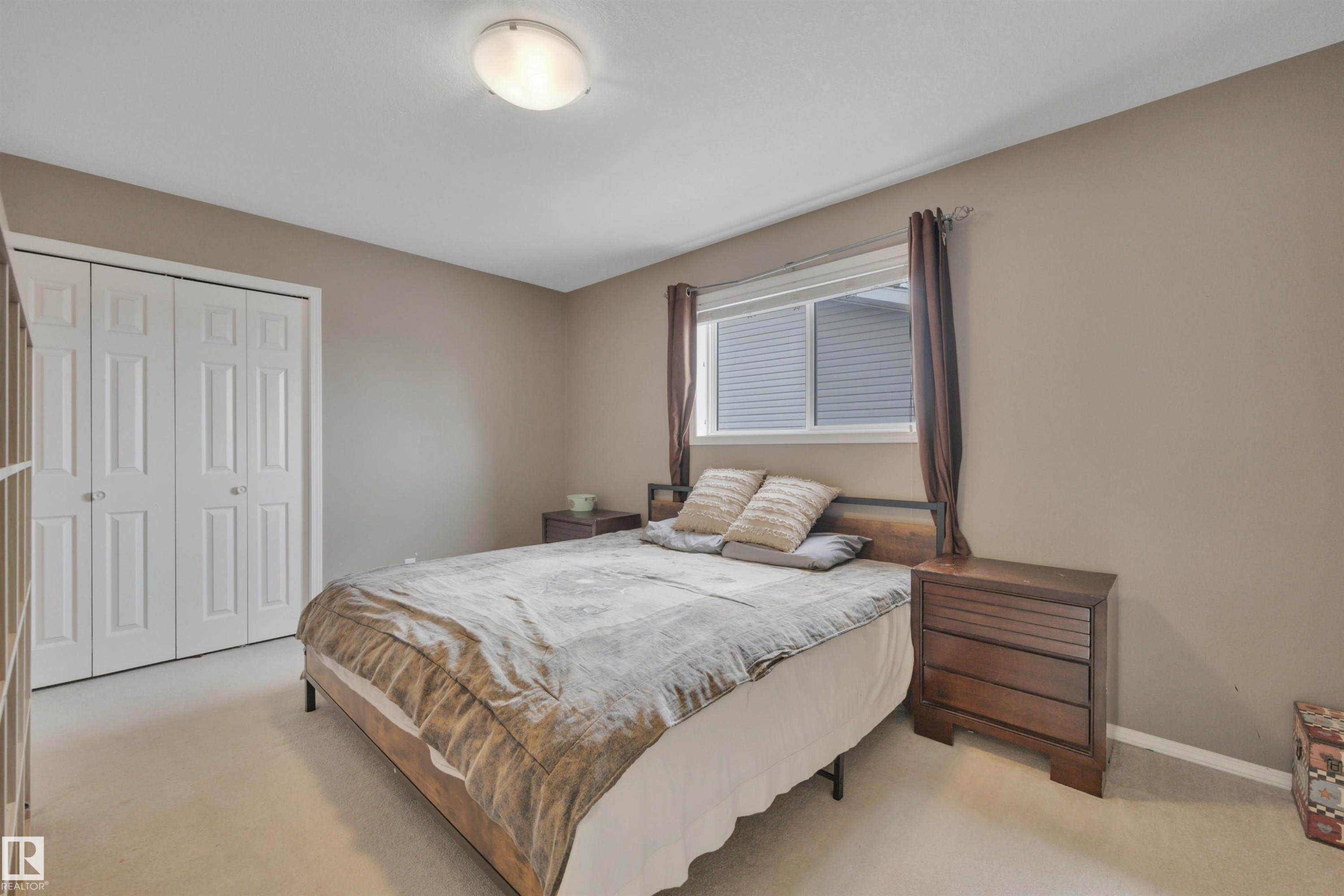 The room features a window providing natural light, neutral-toned walls, and carpeted flooring - 5 Parkview Crescent, Calmar, AB - Indoor Photo Showing Bedroom
