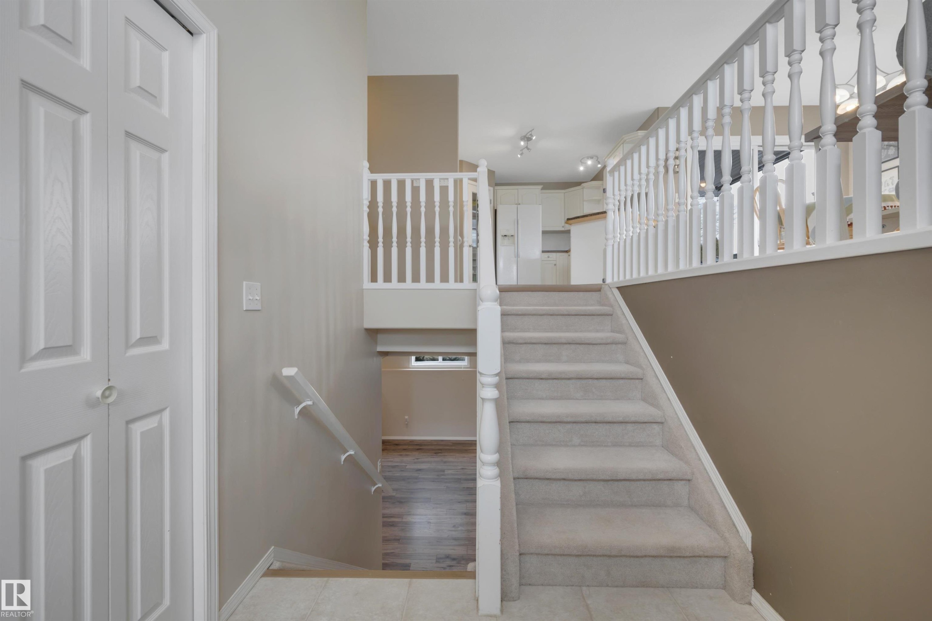 Carpeted staircase with white balusters and railings, featuring light-colored walls - 5 Parkview Crescent, Calmar, AB - Indoor Photo Showing Other Room