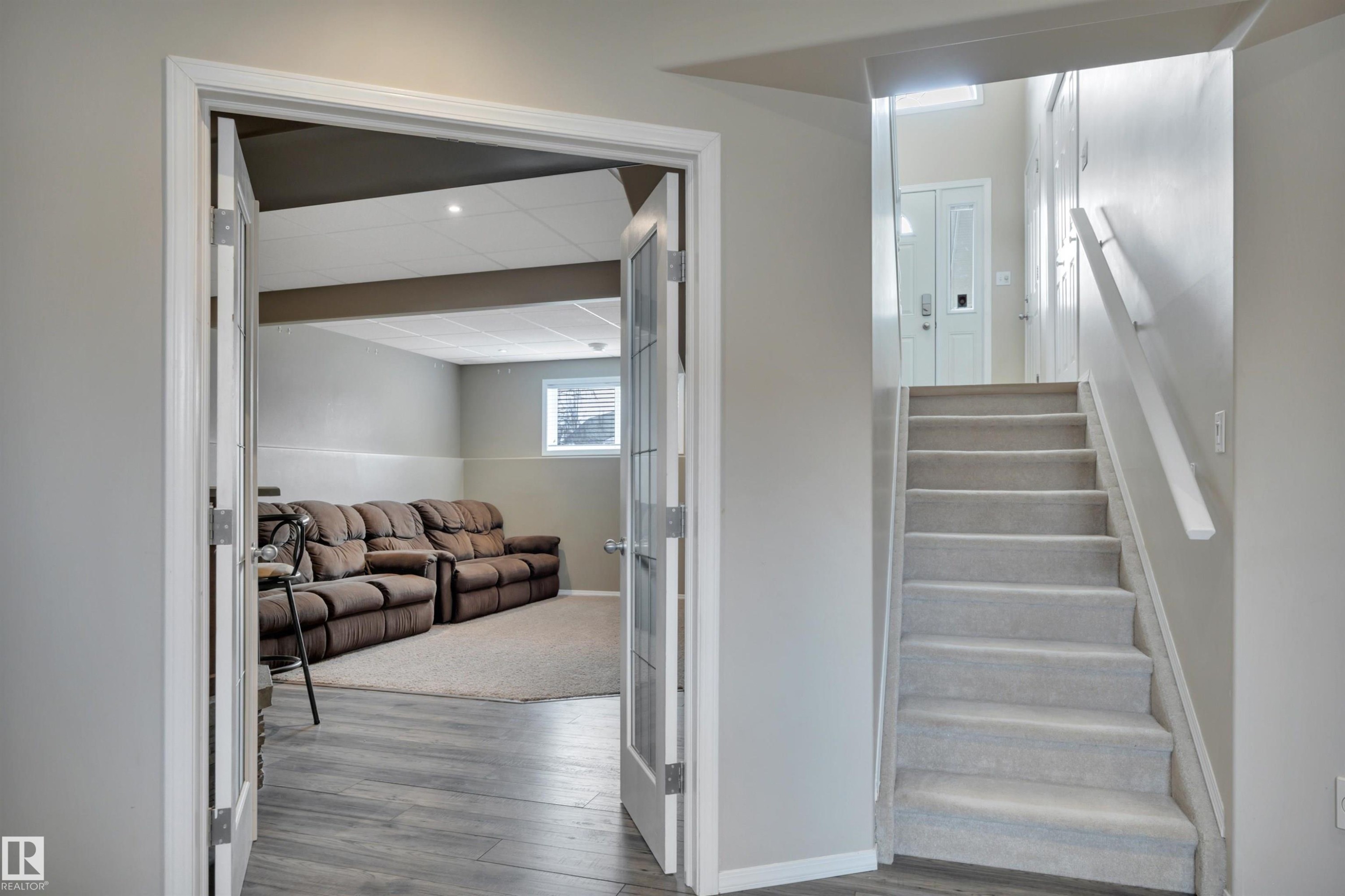 The property features a staircase with carpeted treads and a handrail - 5 Parkview Crescent, Calmar, AB - Indoor Photo Showing Other Room