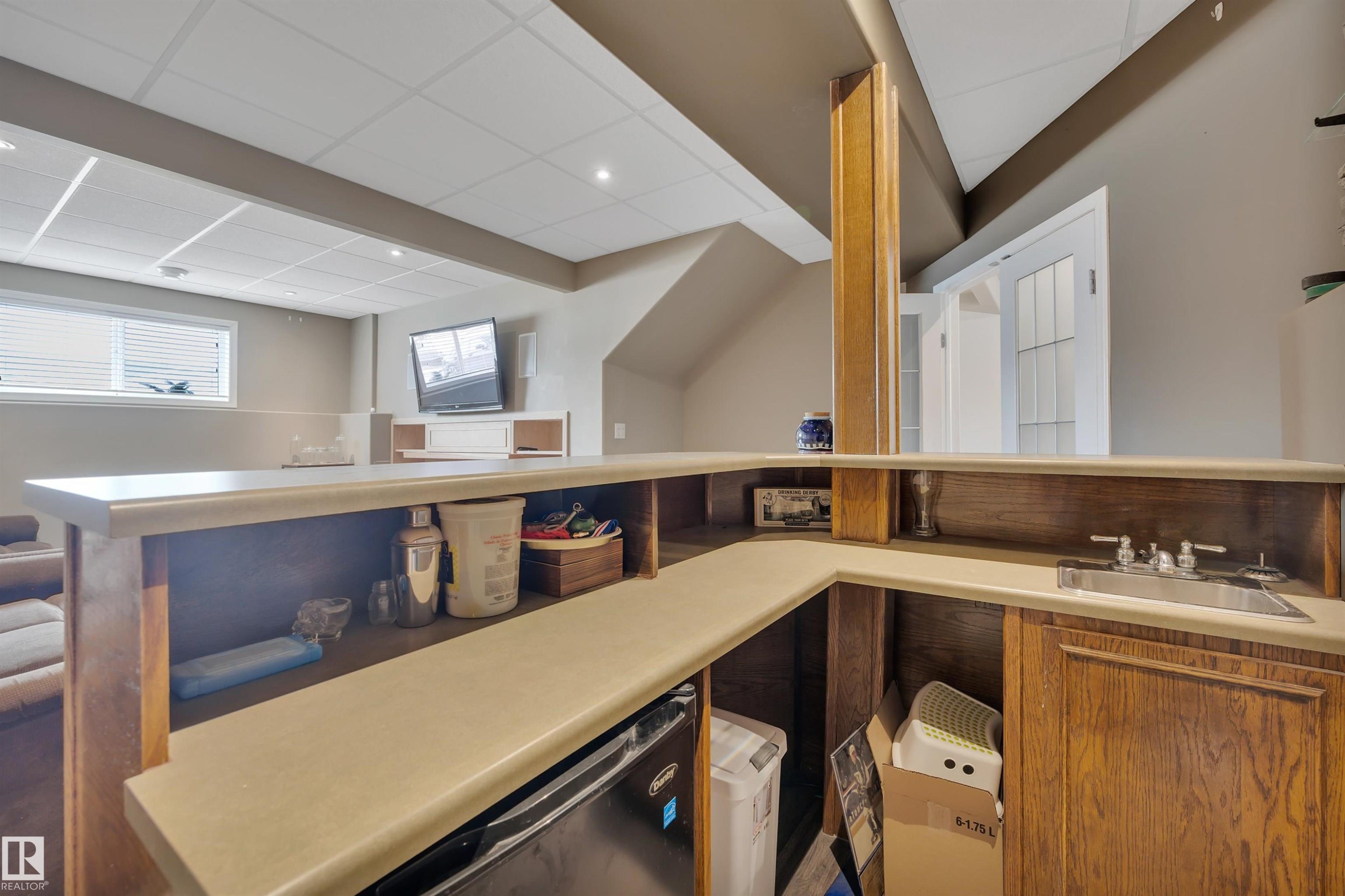 Well-appointed bar area featuring a sink, cabinetry, and a countertop - 5 Parkview Crescent, Calmar, AB - Indoor