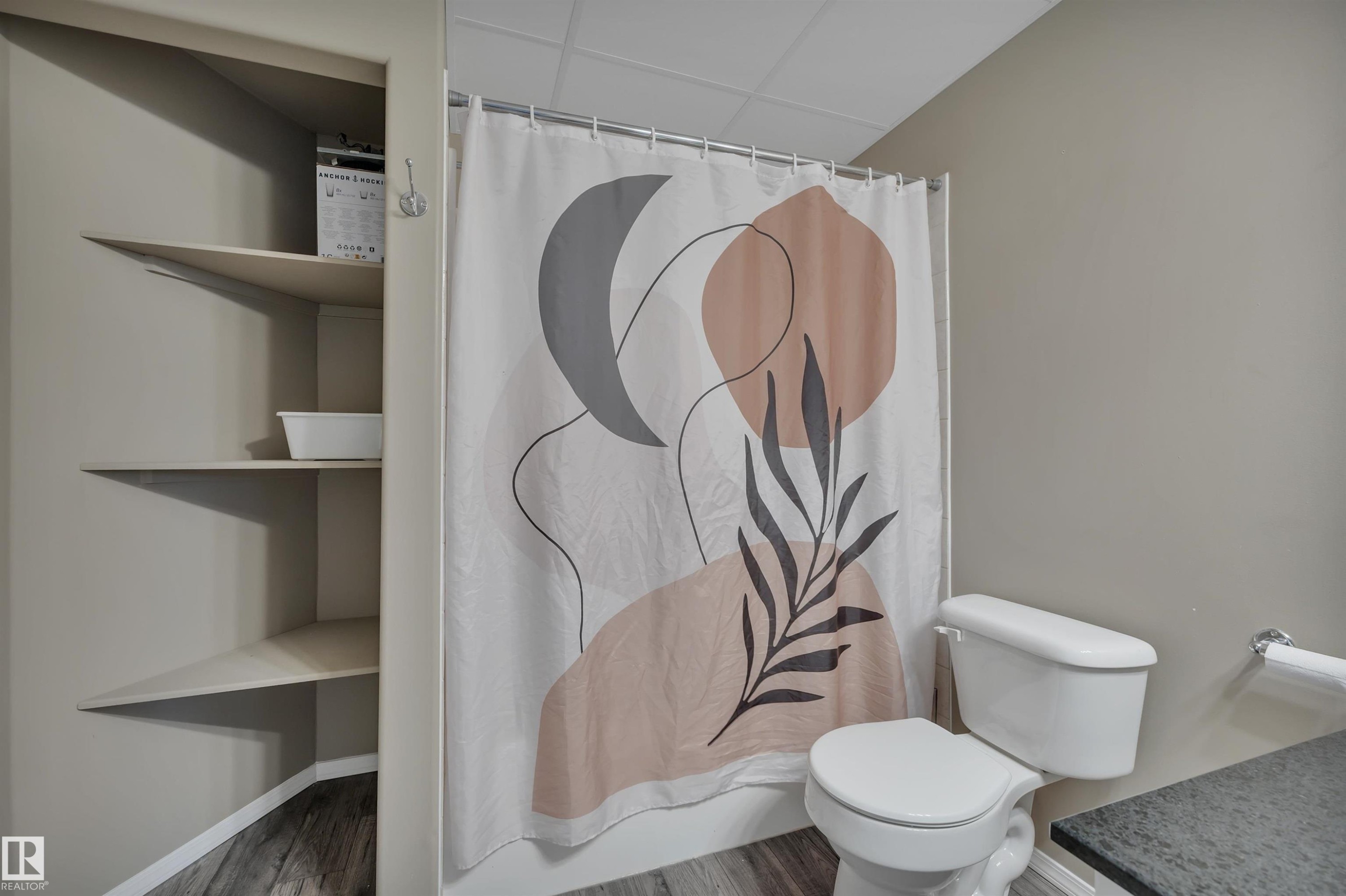 Bathroom featuring a shower with a decorative curtain, a toilet, and built-in shelving - 5 Parkview Crescent, Calmar, AB - Indoor Photo Showing Bathroom