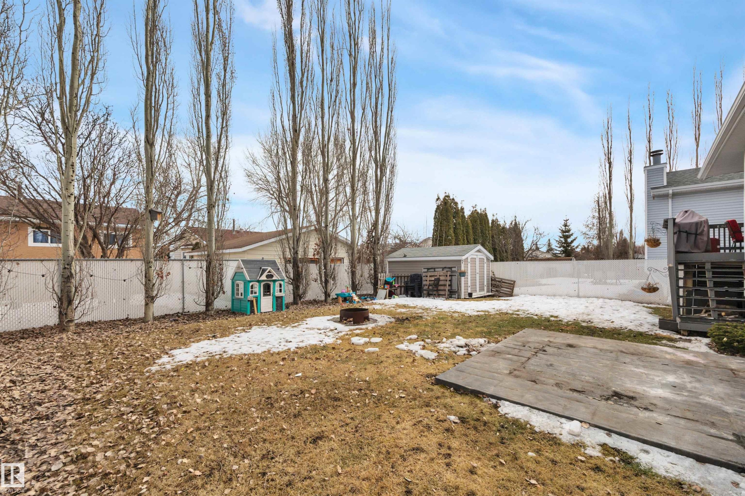 The property features a fenced backyard with a shed, a deck, and mature trees - 5 Parkview Crescent, Calmar, AB - Outdoor