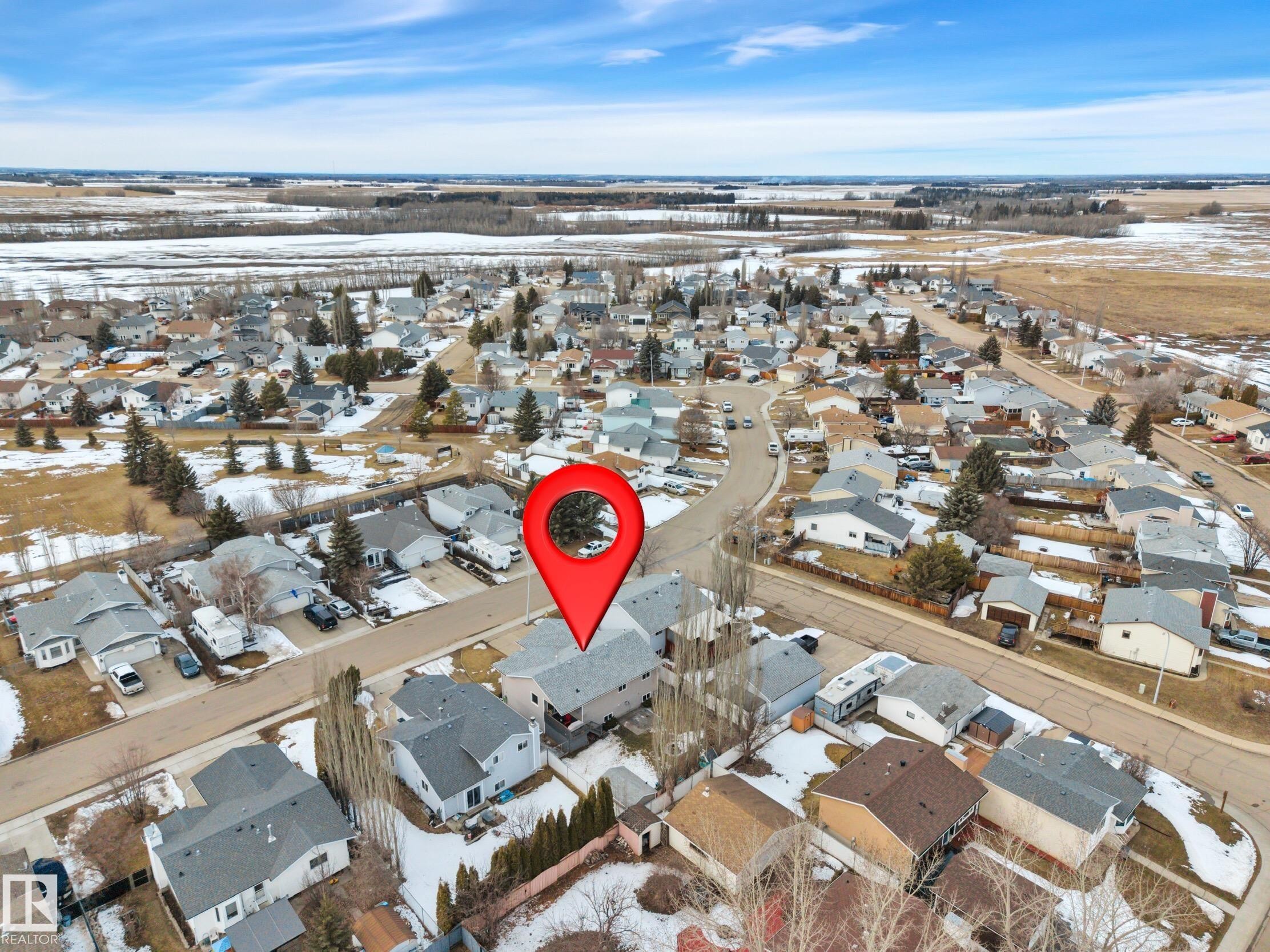 This aerial view showcases a residential area with a collection of properties, each featuring a pitched roof - 5 Parkview Crescent, Calmar, AB - Outdoor With View