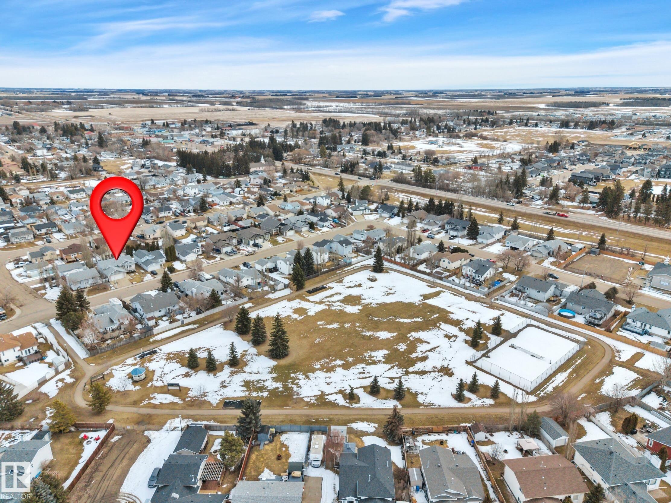 Aerial view of the property's neighborhood, featuring residential homes, green spaces, and a paved road - 5 Parkview Crescent, Calmar, AB - Outdoor With View
