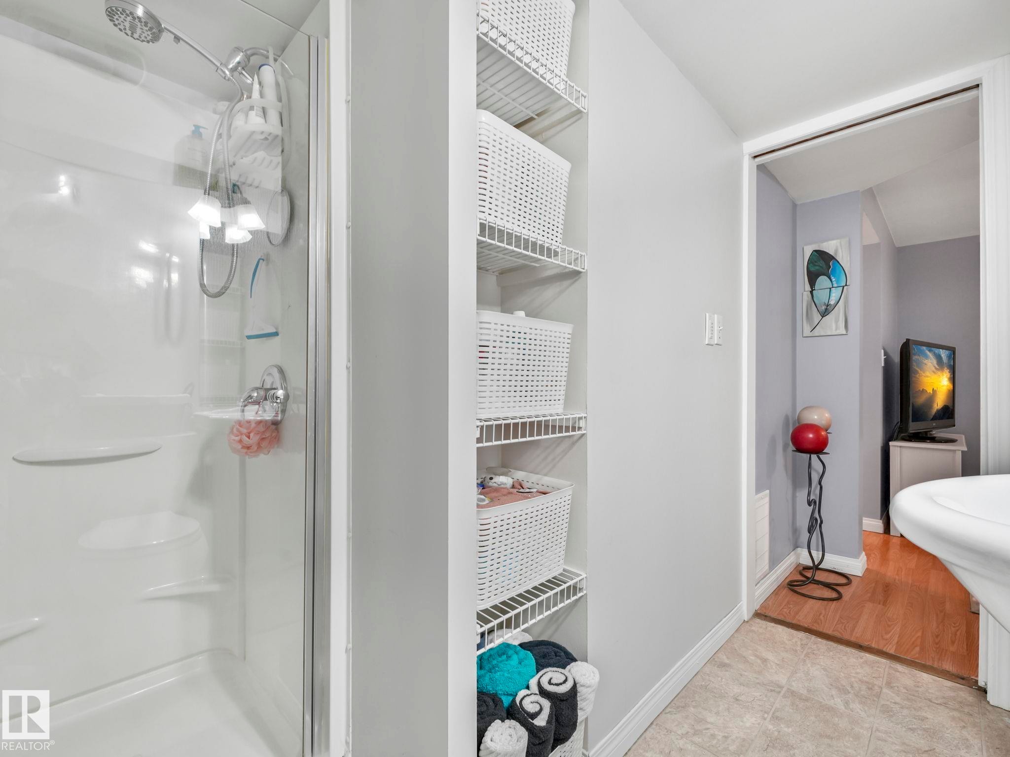 Bathroom featuring a shower stall with clear glass enclosure and a built-in shelf system - 12141 96 Street, Edmonton, AB - Indoor Photo Showing Bathroom