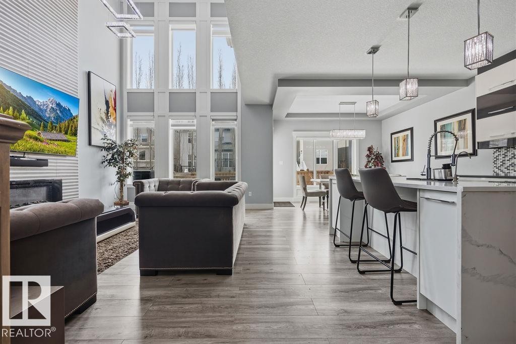 The property features an open-concept living space with high ceilings, large windows, and light-colored flooring - 17534 60A Street, Edmonton, AB - Indoor