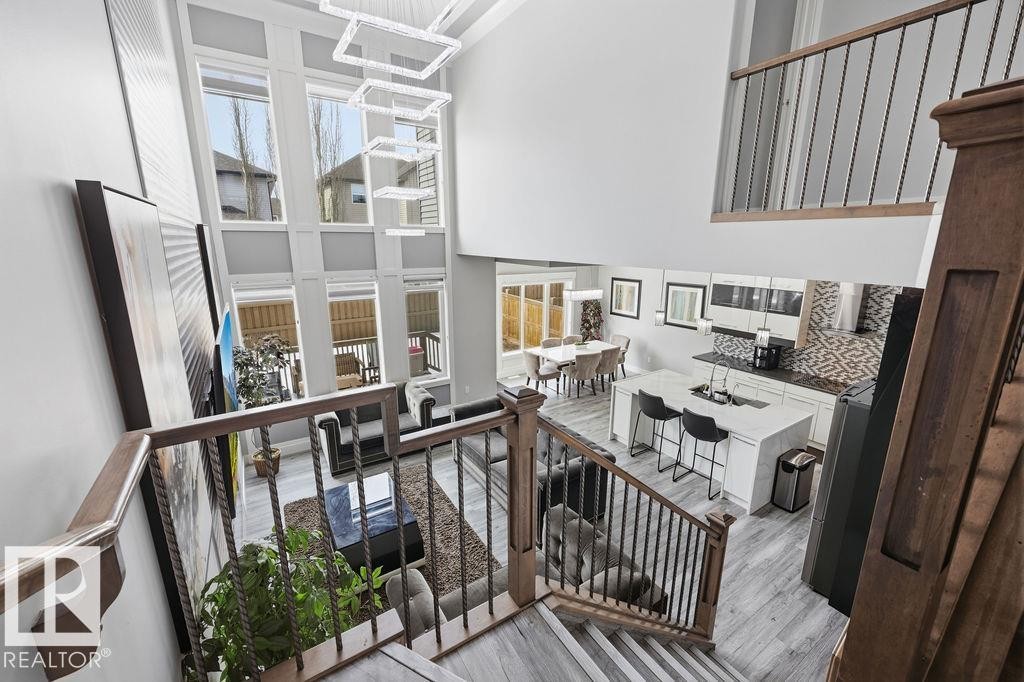 An open-concept living space featuring high ceilings, a two-story window array, and light-toned flooring - 17534 60A Street, Edmonton, AB - Indoor Photo Showing Other Room
