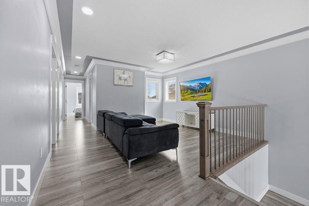 A spacious living area featuring light-toned flooring, recessed lighting, and large windows - 17534 60A Street, Edmonton, AB - Indoor