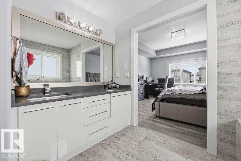 Contemporary bathroom vanity with a single sink, an expansive mirror, and a modern light fixture - 17534 60A Street, Edmonton, AB - Indoor Photo Showing Bathroom