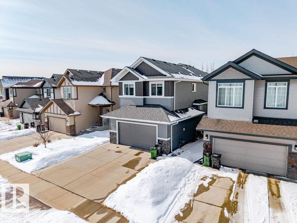 The property features a two-story design with a gray exterior and dark trim, complemented by a front-facing garage - 17534 60A Street, Edmonton, AB - Outdoor With Facade