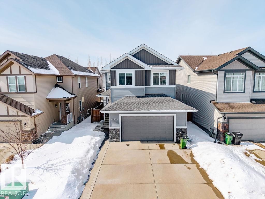 The property features a two-story exterior with a gray and dark gray facade, an attached garage, and a concrete driveway - 17534 60A Street, Edmonton, AB - Outdoor With Facade
