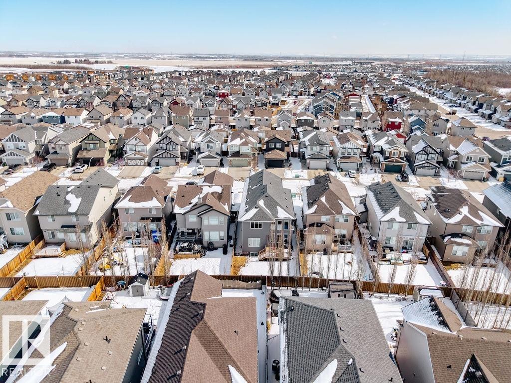 This aerial view showcases a residential area with numerous detached properties, each featuring a pitched roof and individual fenced yards - 17534 60A Street, Edmonton, AB - Outdoor With View
