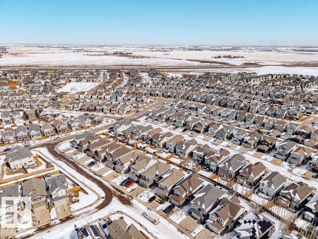 Aerial view of the neighborhood featuring a collection of properties with varied rooflines and a clear sky, bordered by snow-covered fields - 17534 60A Street, Edmonton, AB - Outdoor With View