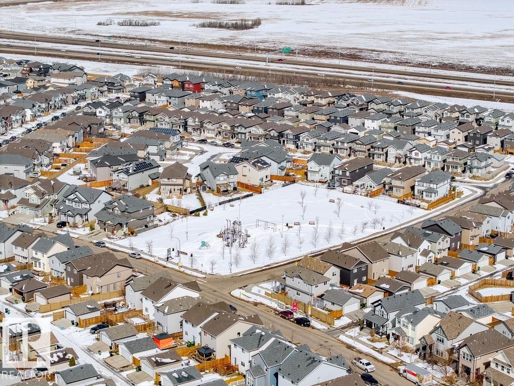 Overhead view of a residential neighbourhood featuring a large central park area with playground equipment, surrounded by properties with varying architectural styles - 17534 60A Street, Edmonton, AB - Outdoor With View