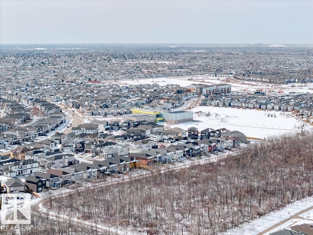 An aerial perspective showcases the surrounding area, featuring residential properties, roadways, and natural tree coverage - 17534 60A Street, Edmonton, AB - Outdoor With View