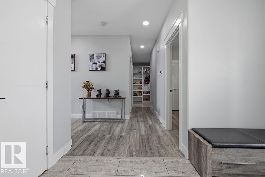 Hallway featuring light wood-style flooring, recessed lighting, and a white door with horizontal paneling - 17534 60A Street, Edmonton, AB - Indoor Photo Showing Other Room