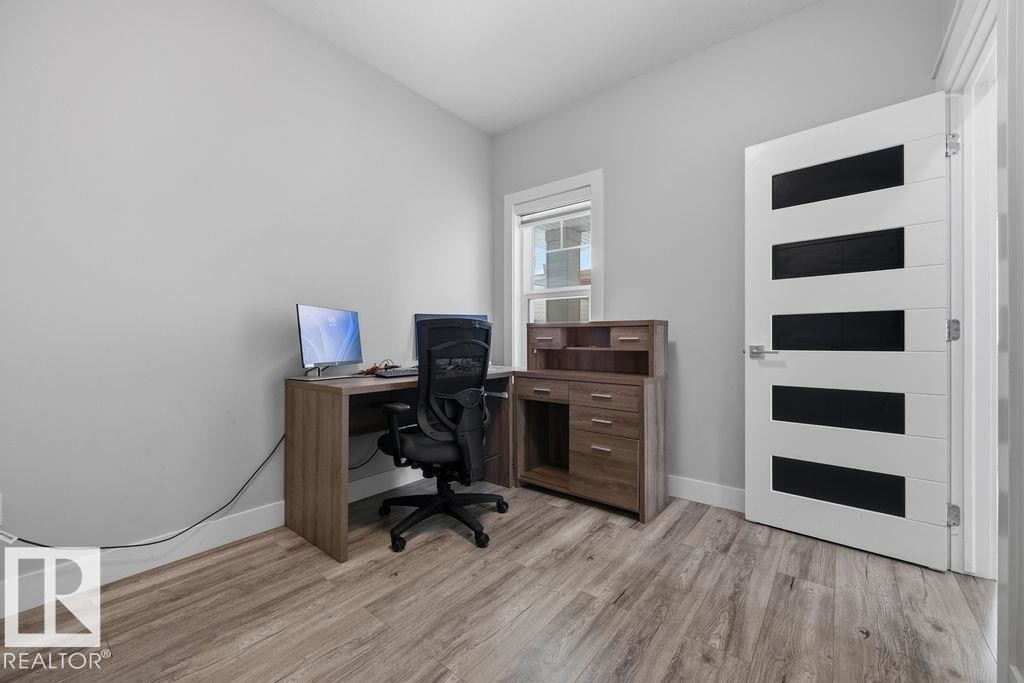 This versatile room features light-toned walls, wood-style flooring, and a window providing natural light - 17534 60A Street, Edmonton, AB - Indoor Photo Showing Office