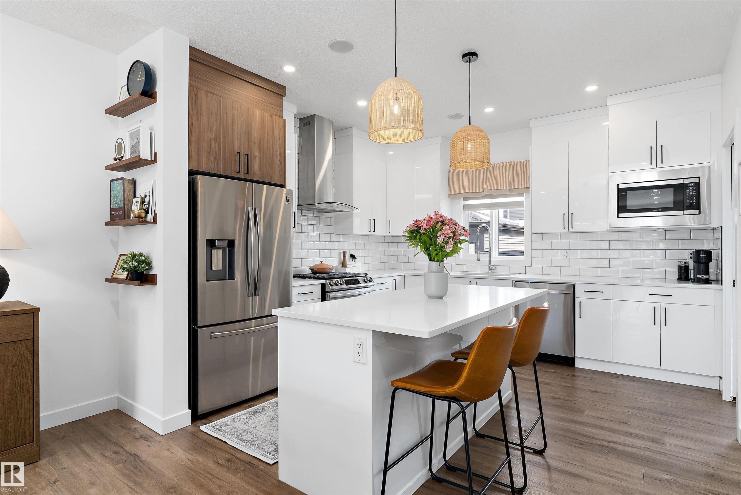 Modern kitchen featuring a white island with a quartz countertop, stainless steel appliances, white subway tile backsplash, and wood-look flooring - 1305 Enright Landing, Edmonton, AB - Indoor Photo Showing Kitchen With Stainless Steel Kitchen With Upgraded Kitchen