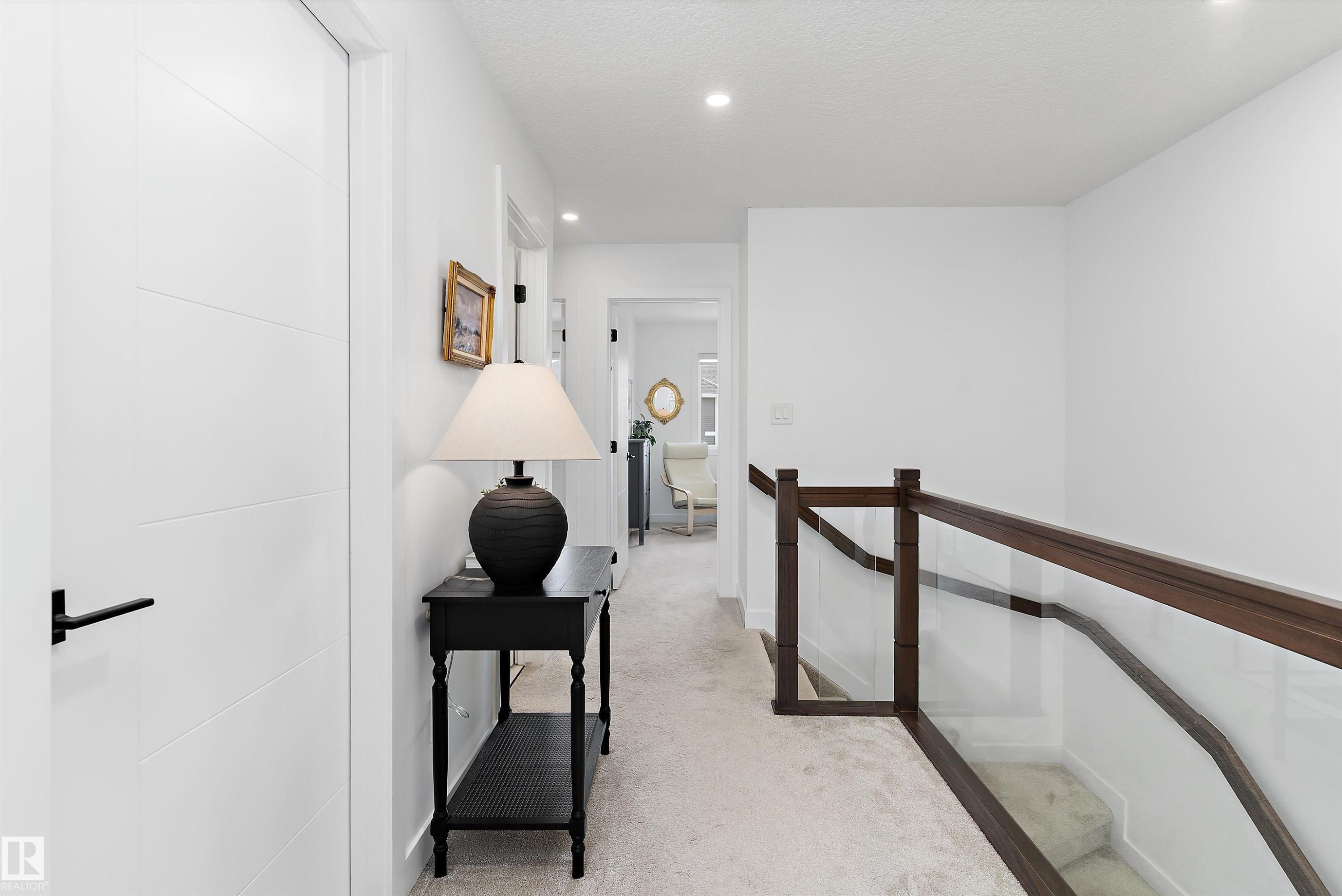 The property features a bright hallway with white walls, recessed lighting, and light-colored carpeting - 1305 Enright Landing, Edmonton, AB - Indoor Photo Showing Other Room