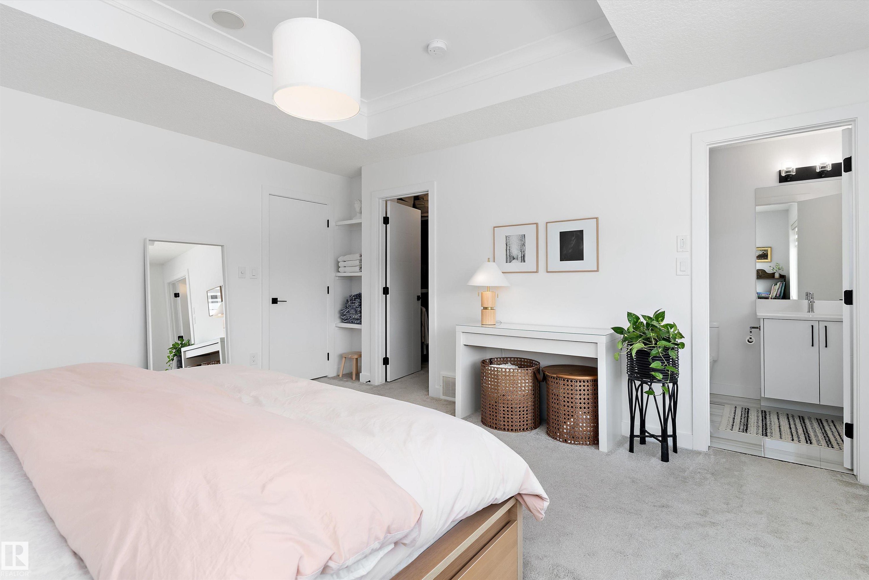 Spacious room featuring light-colored carpeting, a tray ceiling, and a bright white color palette - 1305 Enright Landing, Edmonton, AB - Indoor Photo Showing Bedroom