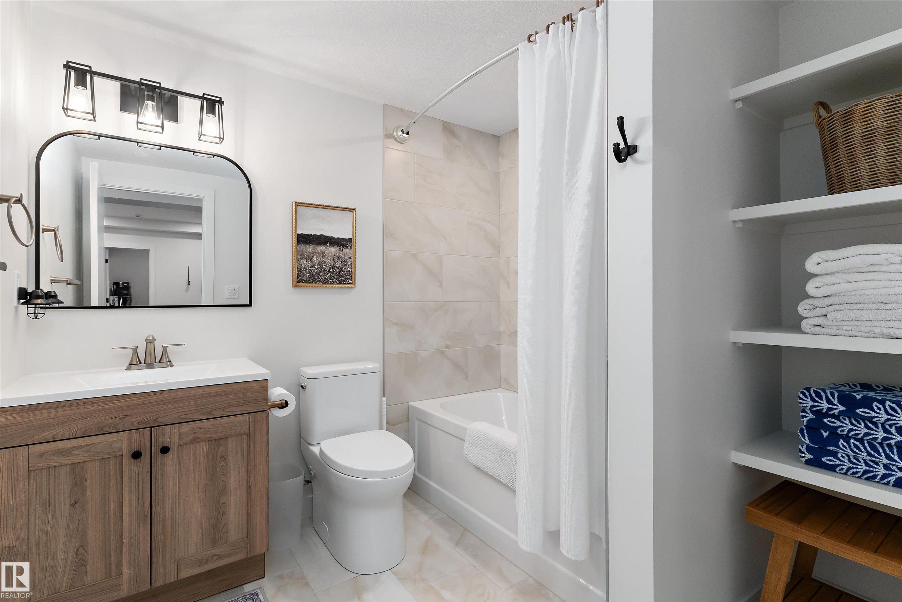 This bathroom features a wood-tone vanity with a white countertop and a contemporary black-framed mirror - 1305 Enright Landing, Edmonton, AB - Indoor Photo Showing Bathroom
