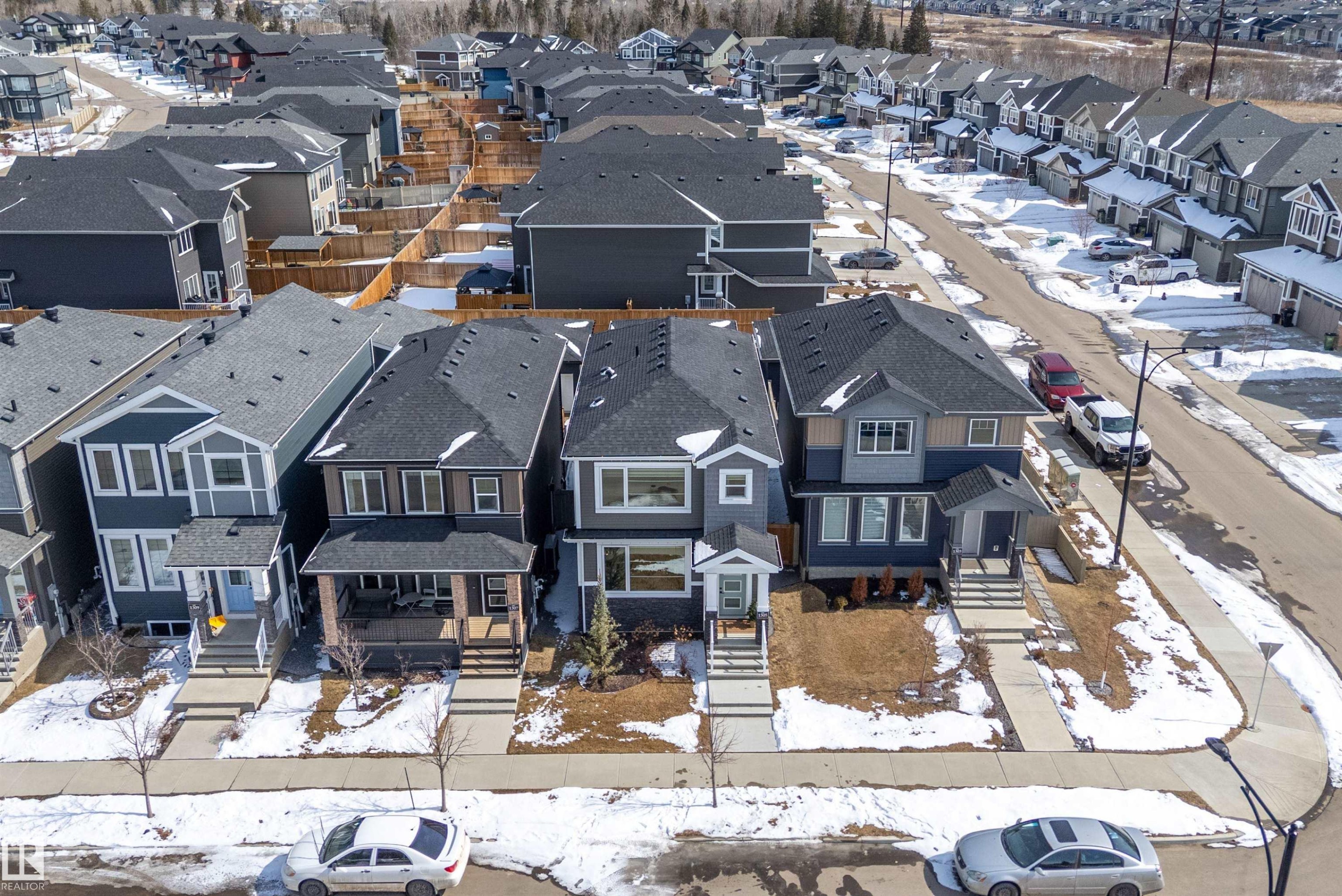 The property features a dark-colored roof and a multi-level exterior - 1305 Enright Landing, Edmonton, AB - Outdoor With Facade