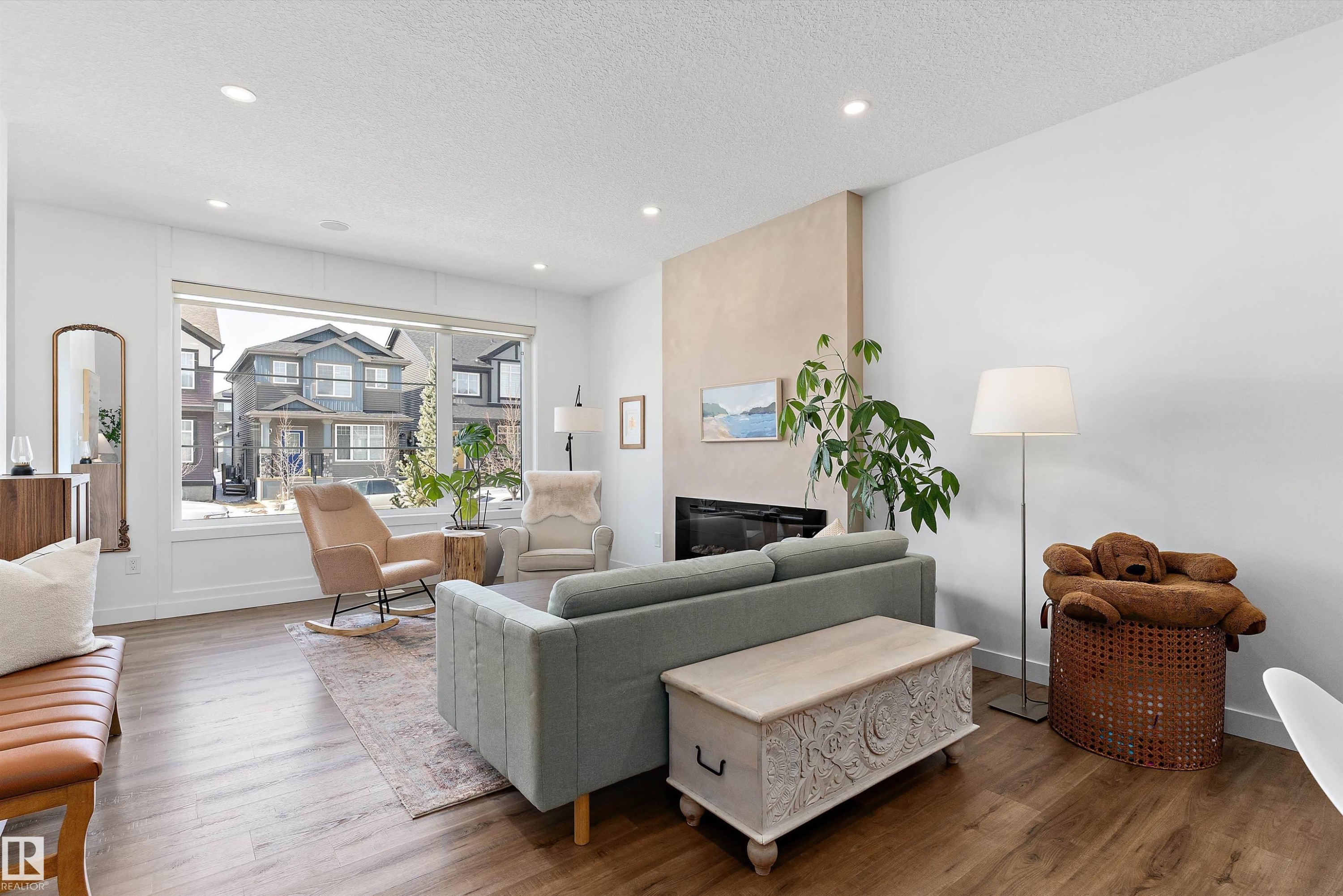 The living area features wood-style flooring, a large window, and recessed lighting - 1305 Enright Landing, Edmonton, AB - Indoor Photo Showing Living Room