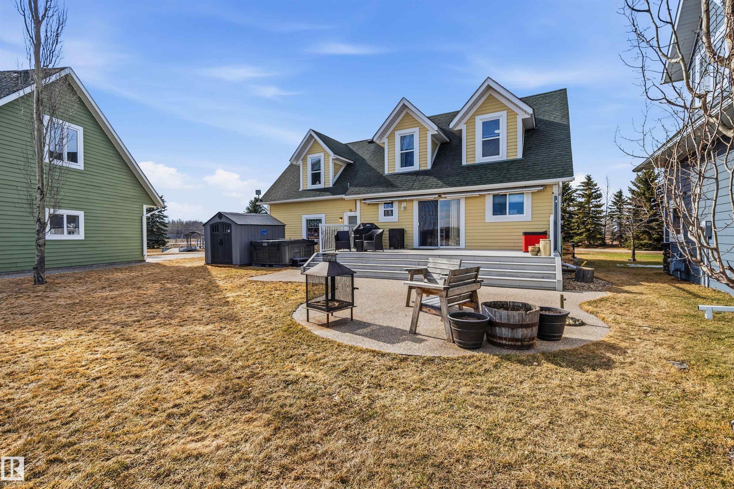 The property features a spacious deck and patio area, perfect for outdoor enjoyment - 17 Sunset Harbour, Rural Wetaskiwin County, AB - Outdoor