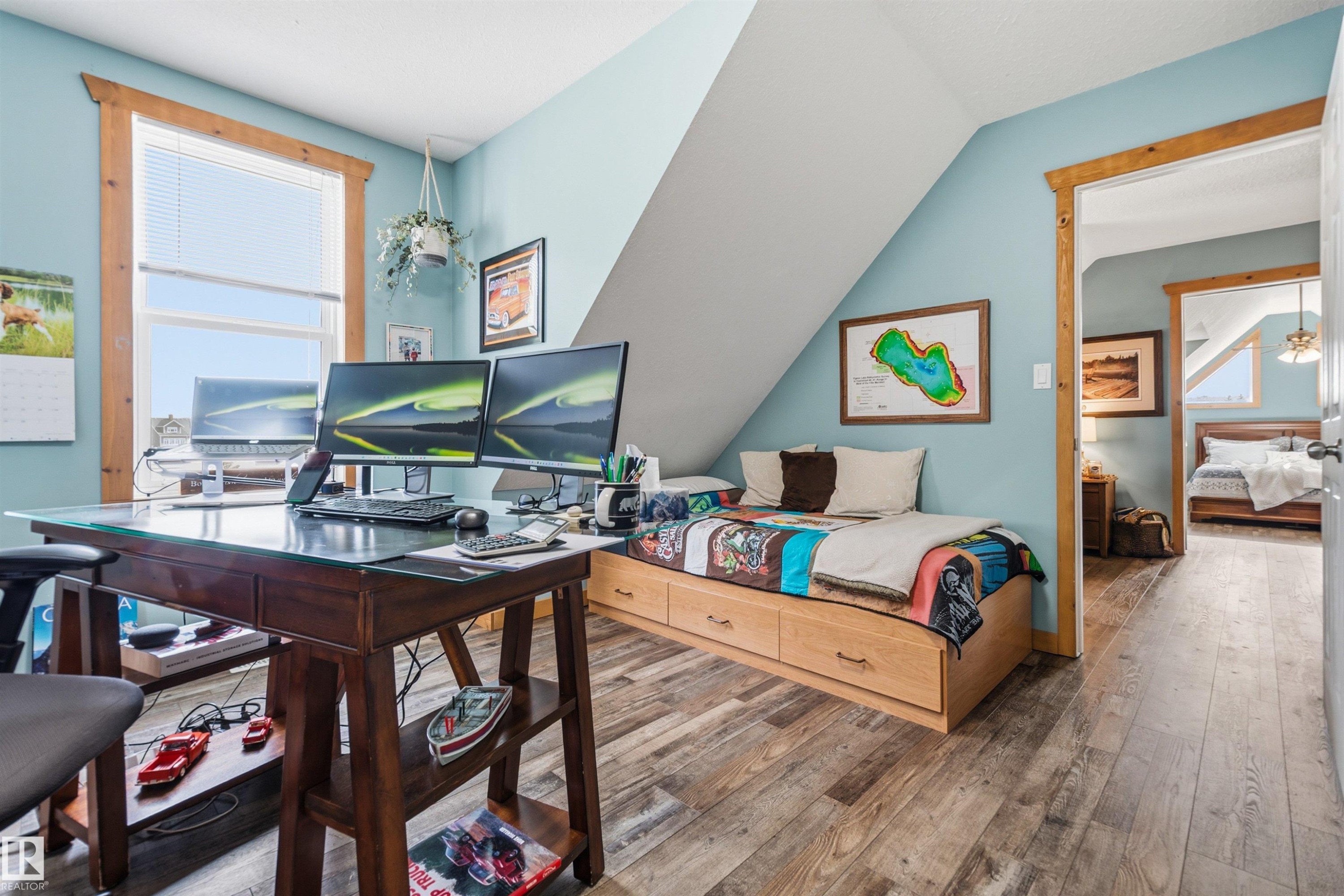This room features a window with blinds, light blue walls, and wood-look flooring - 17 Sunset Harbour, Rural Wetaskiwin County, AB - Indoor Photo Showing Bedroom