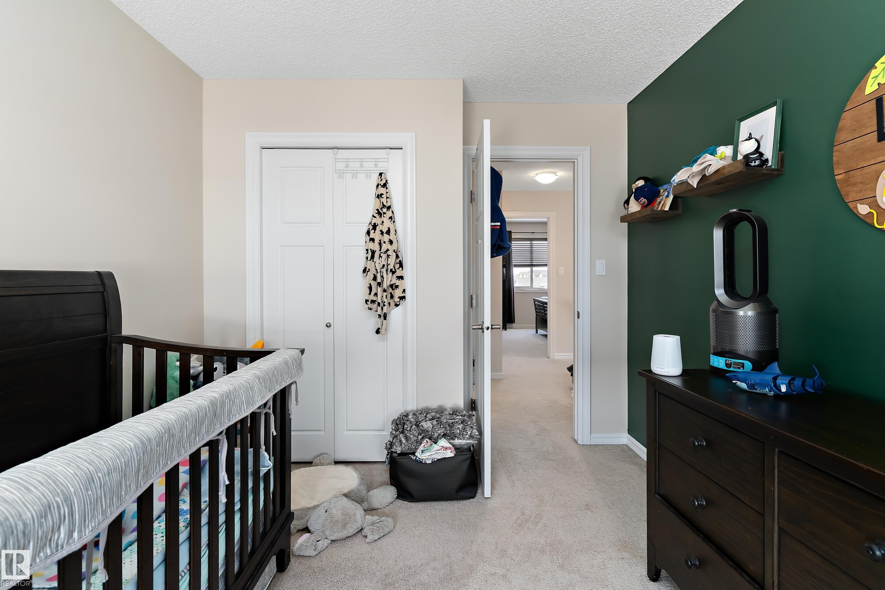 The room features two-tone walls, a carpeted floor, and a closet with bifold doors - 6822 Cardinal Link, Edmonton, AB - Indoor Photo Showing Bedroom