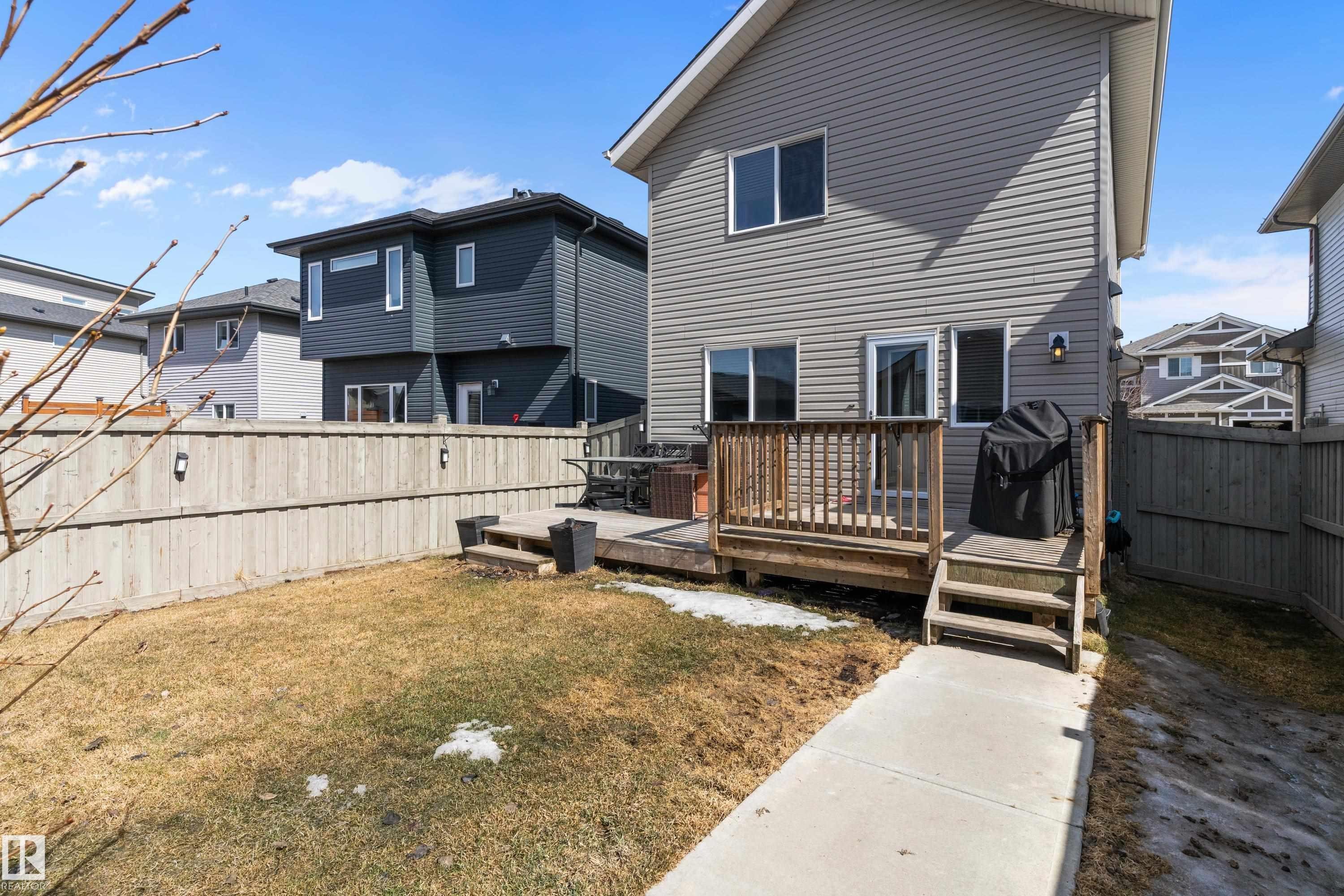 The property features a wooden deck with railing, accessible via a short set of stairs - 6822 Cardinal Link, Edmonton, AB - Outdoor With Deck Patio Veranda