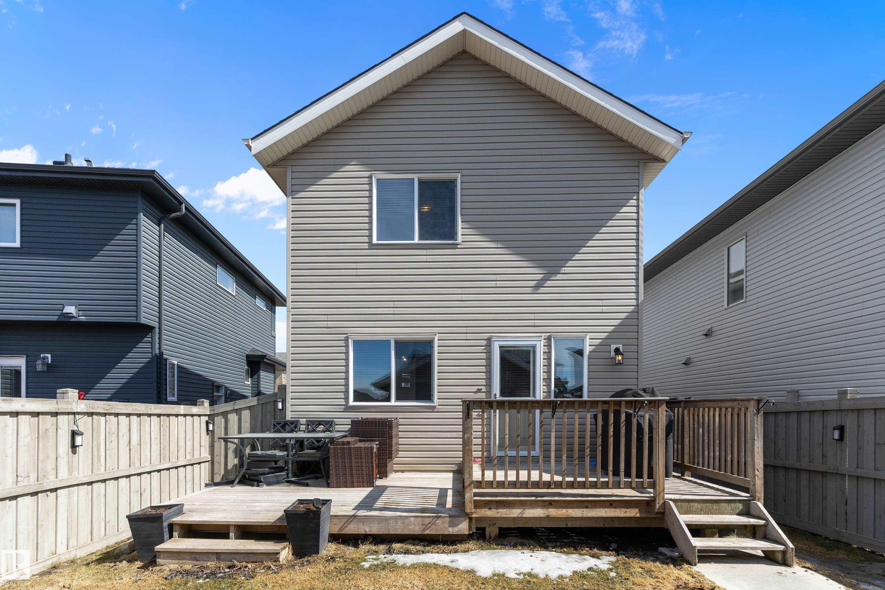The property features a wooden deck with railing and stairs, providing an outdoor living area - 6822 Cardinal Link, Edmonton, AB - Outdoor With Exterior
