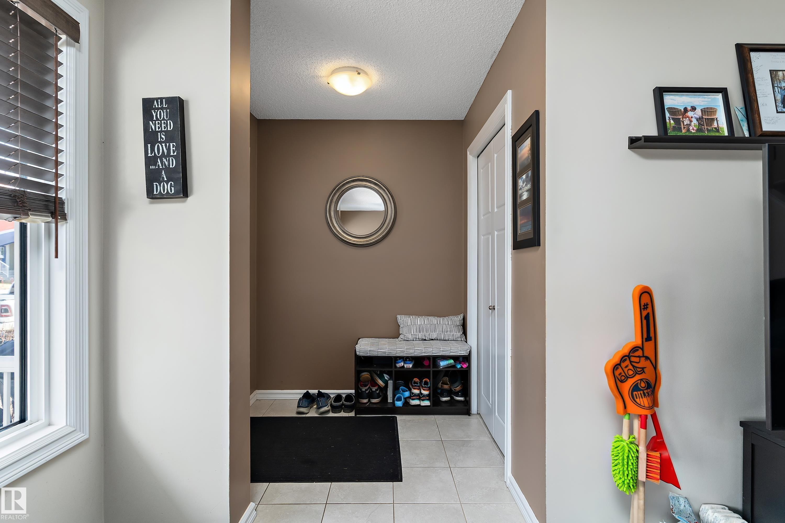 The property features a bright entryway with a window, a neutral color palette, and tiled flooring - 6822 Cardinal Link, Edmonton, AB - Indoor Photo Showing Other Room