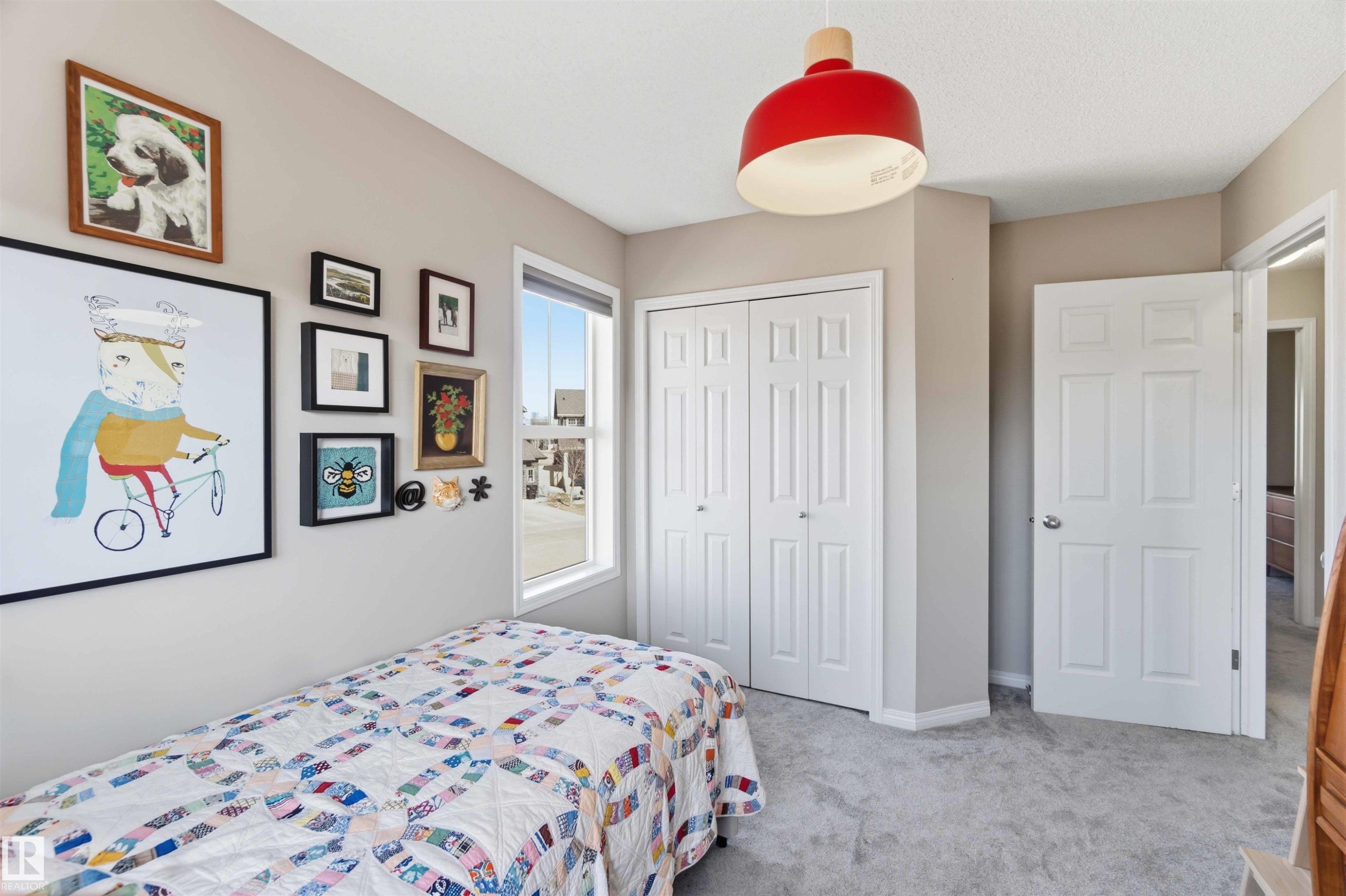This room features light-colored walls, a window providing natural light, and plush grey carpeting - 4750 Crabapple Run, Edmonton, AB - Indoor Photo Showing Bedroom