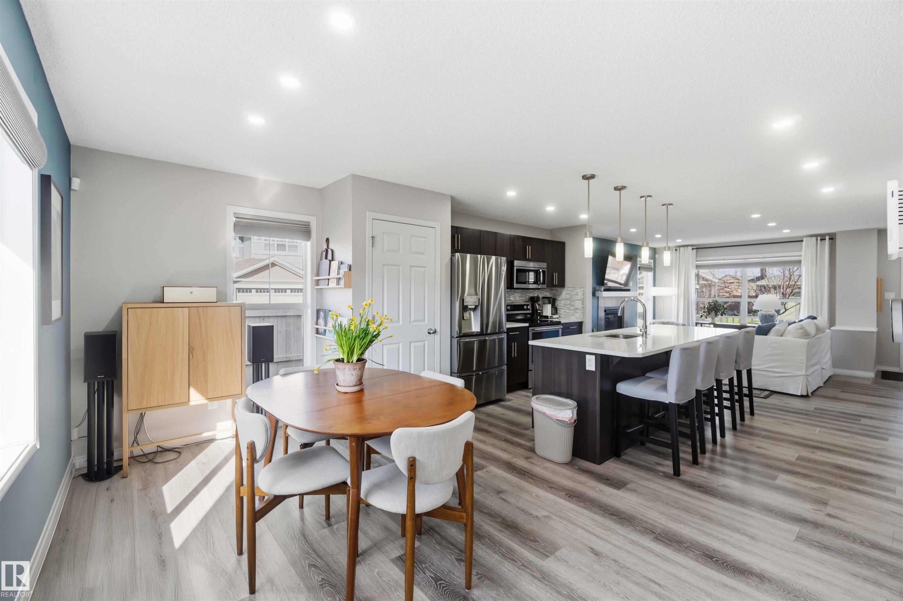 Open concept living space featuring light-toned flooring, recessed lighting, and a kitchen island with pendant lights - 4750 Crabapple Run, Edmonton, AB - Indoor Photo Showing Dining Room