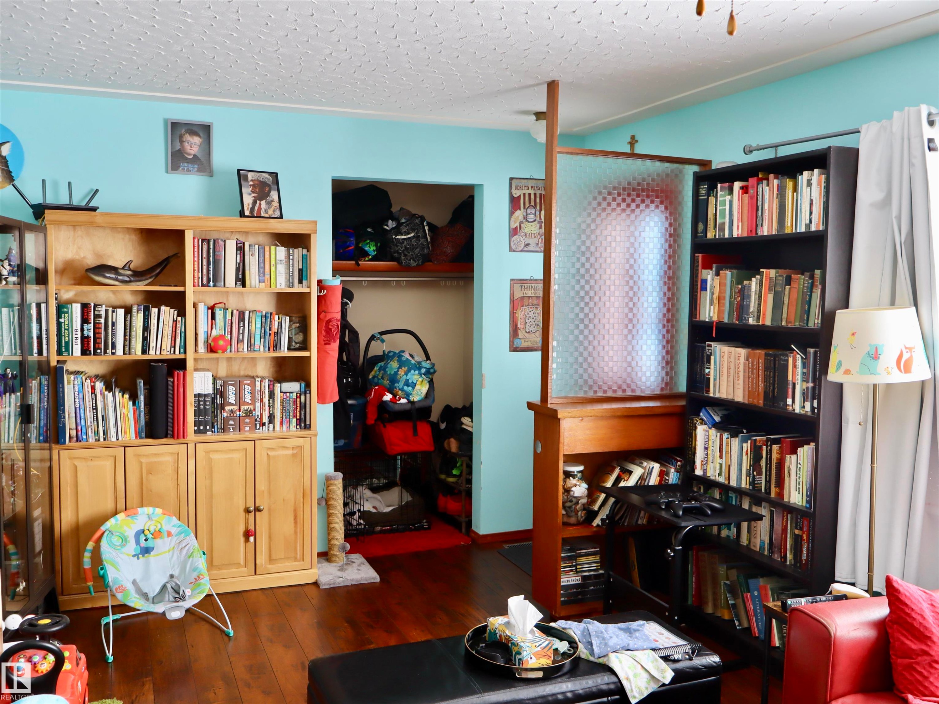 The interior features light blue walls, hardwood flooring, and a textured ceiling - 4315 56 Avenue, Barrhead, AB - Indoor