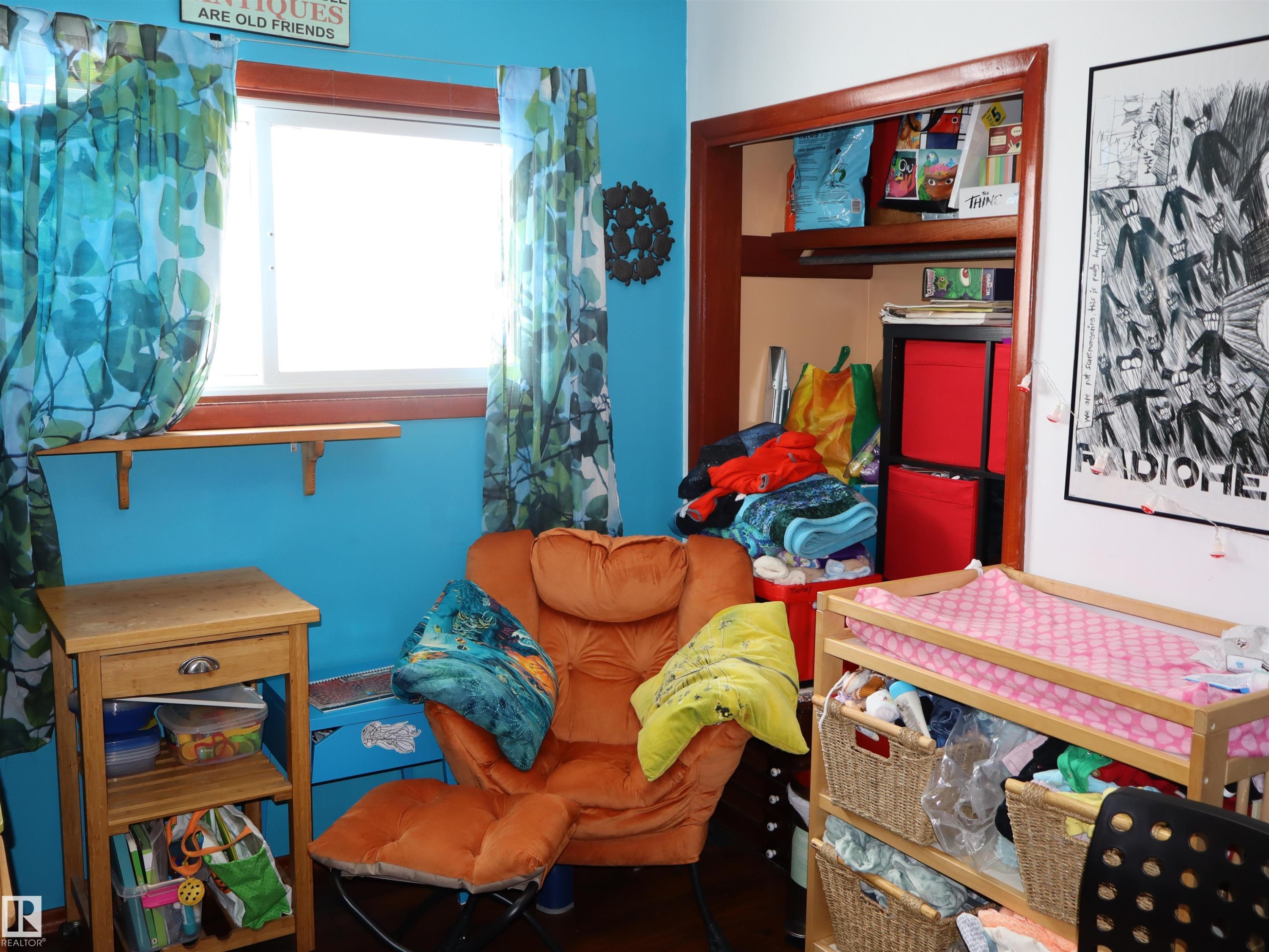 The property features a room with a window, a built-in closet, and vibrant blue walls - 4315 56 Avenue, Barrhead, AB - Indoor Photo Showing Other Room