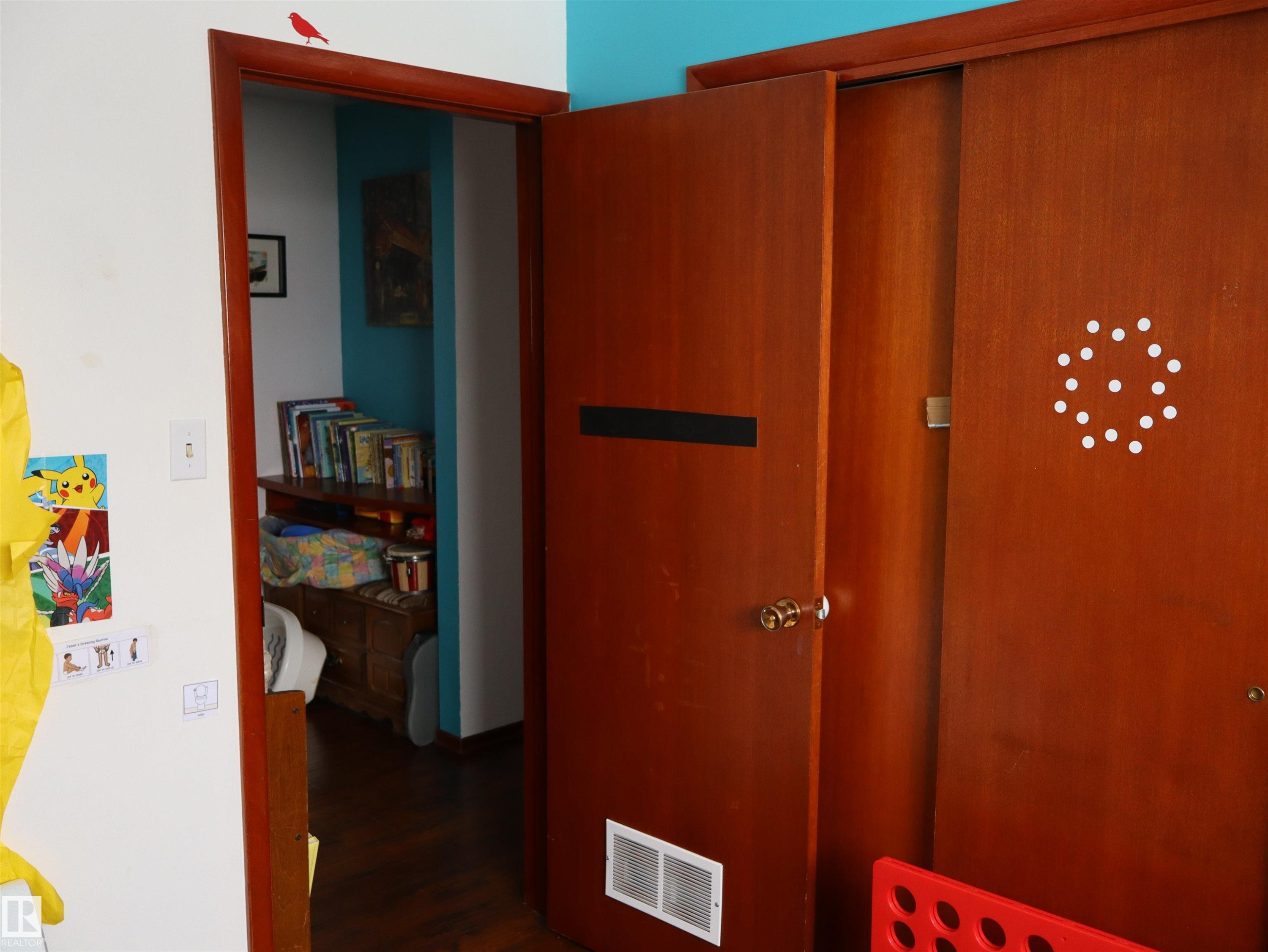 Interior view featuring a wooden door and an open doorway - 4315 56 Avenue, Barrhead, AB - Indoor Photo Showing Other Room